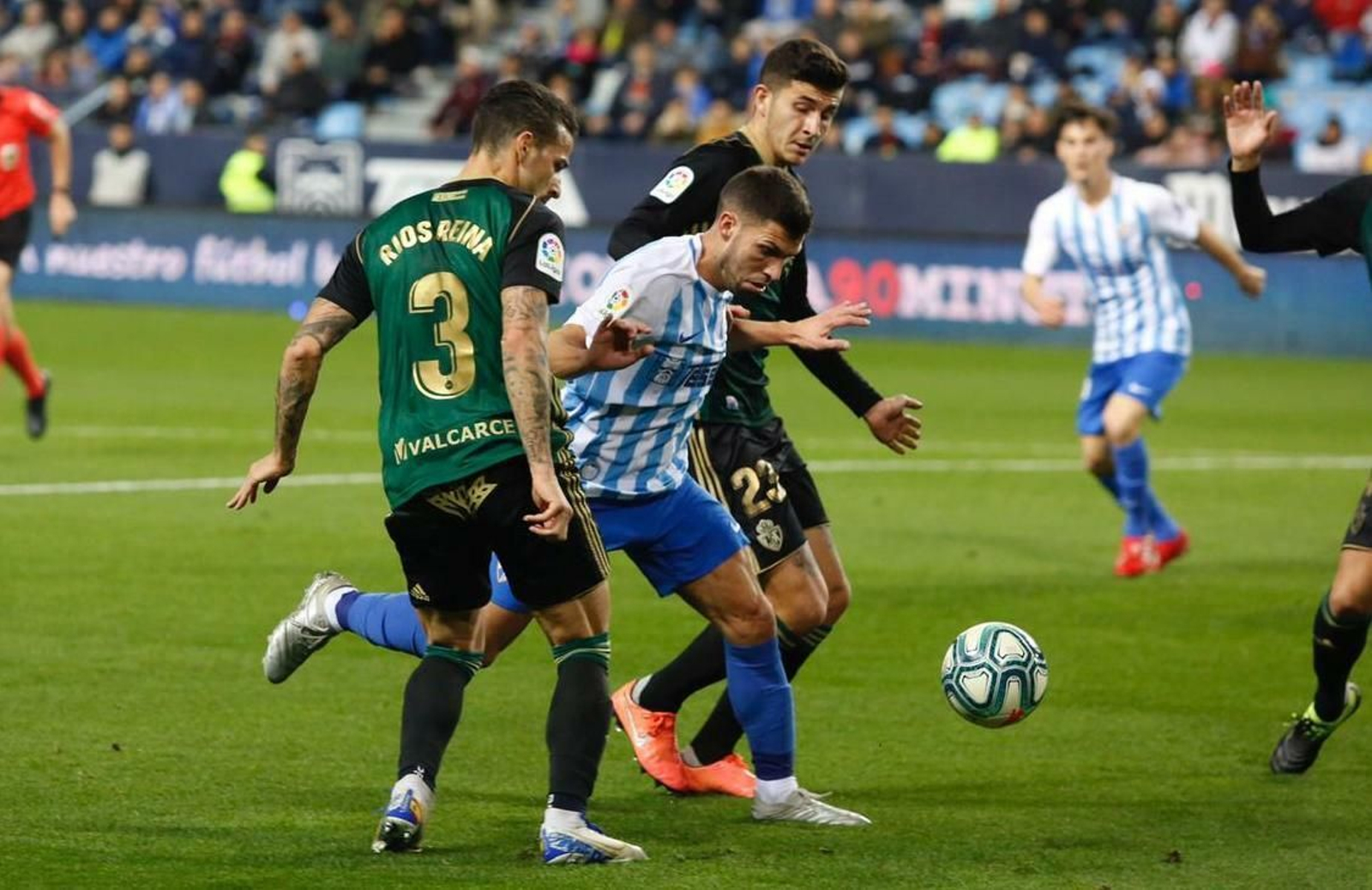 El malaguista Dani Pacheco entre dos rivales durante el partido.