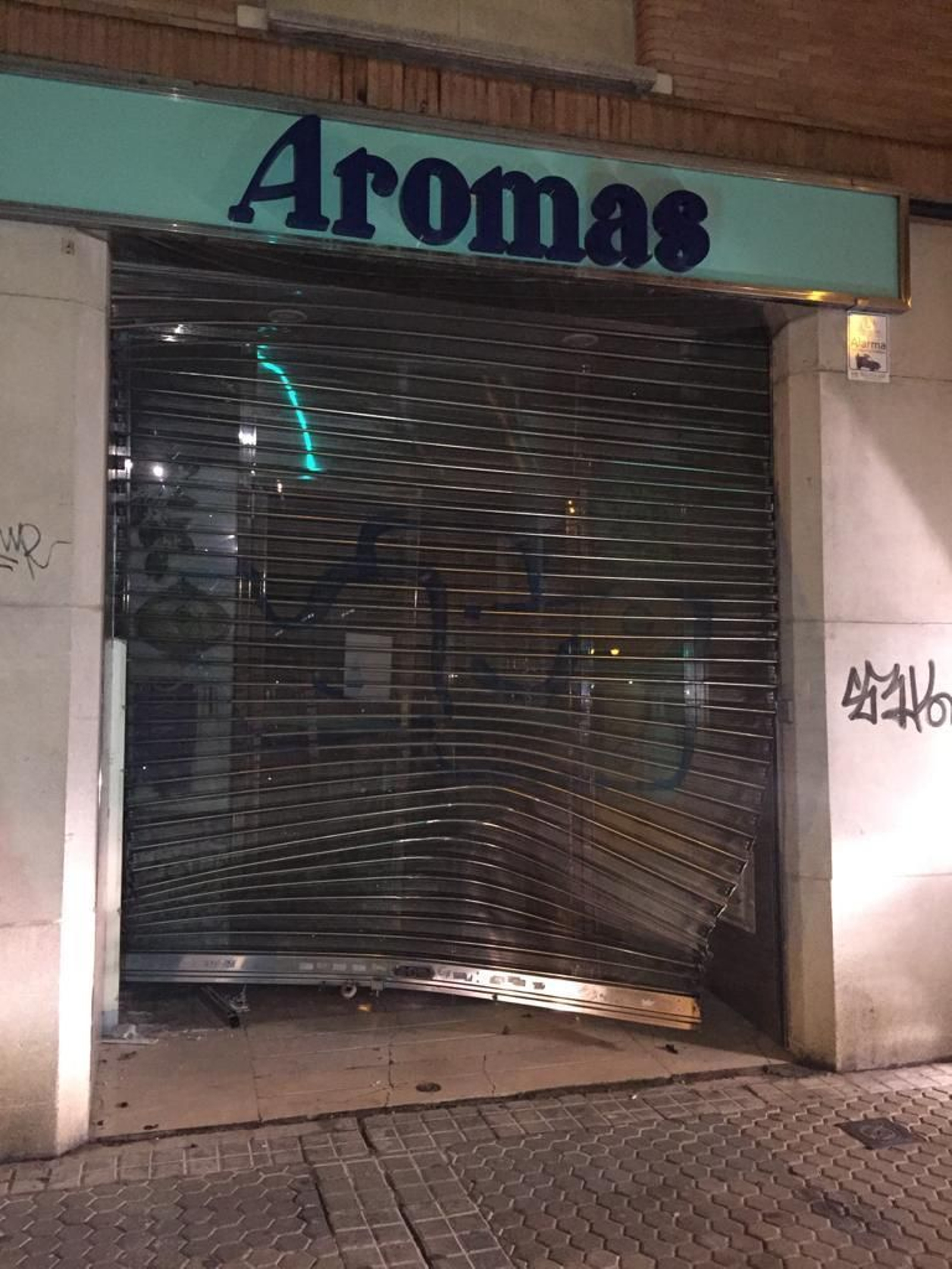La persiana metálica de acceso a la tienda tras el alunizaje.