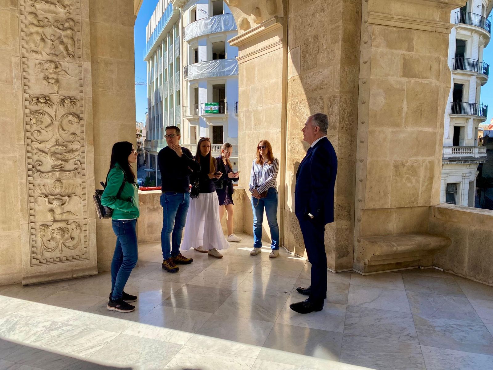Un grupo de visitantes en la terraza del Ayuntamiento, acompañados por el alcalde de Sevilla.