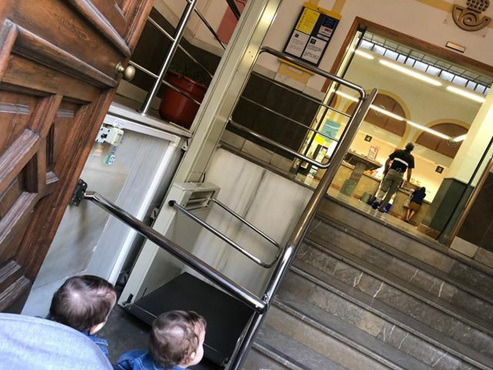 Imagen de los dos niños de la denunciante ante el ascensor del Correos que no pudieron usar.