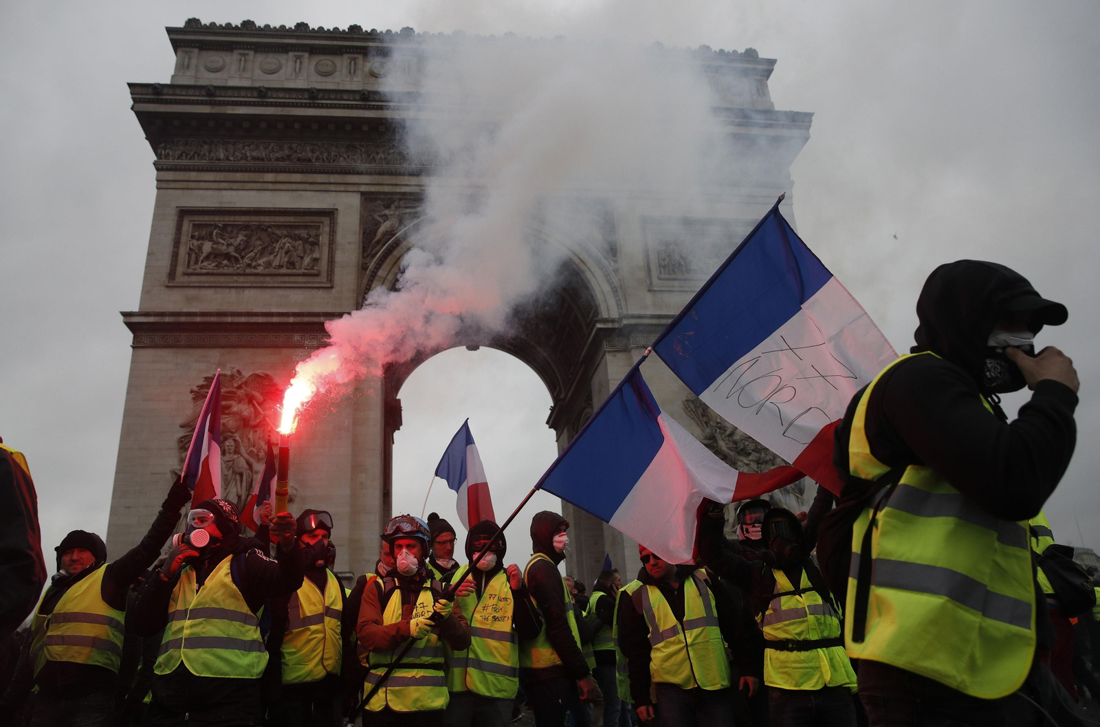 Varios manifestantes pertrechados con chalecos amarillos protestan ayer en el Arco del Triunfo de París.