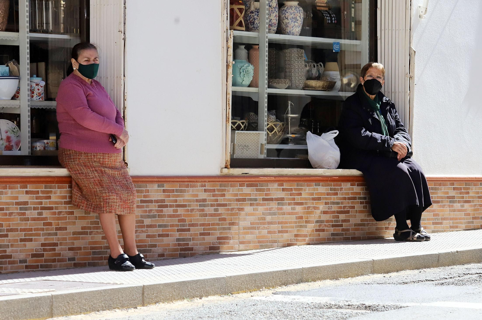 Dos mujeres sentadas al sol en la localidad de Palos de la Frontera.