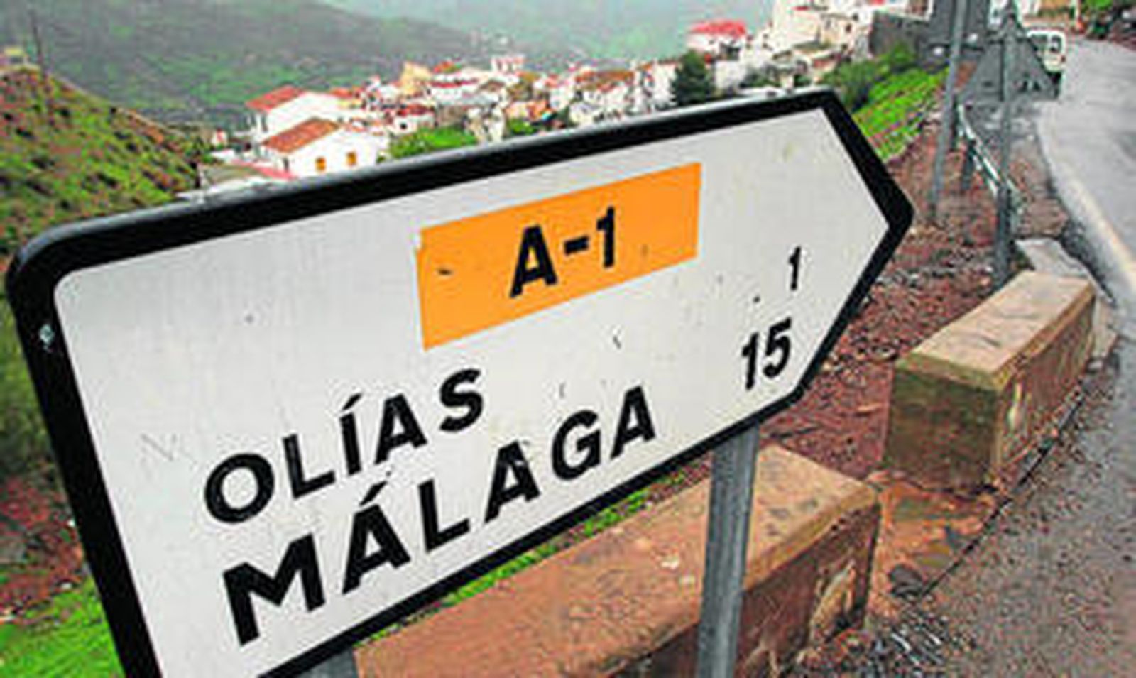 Cartel que señala la distancia de Olías hasta Málaga capital.
