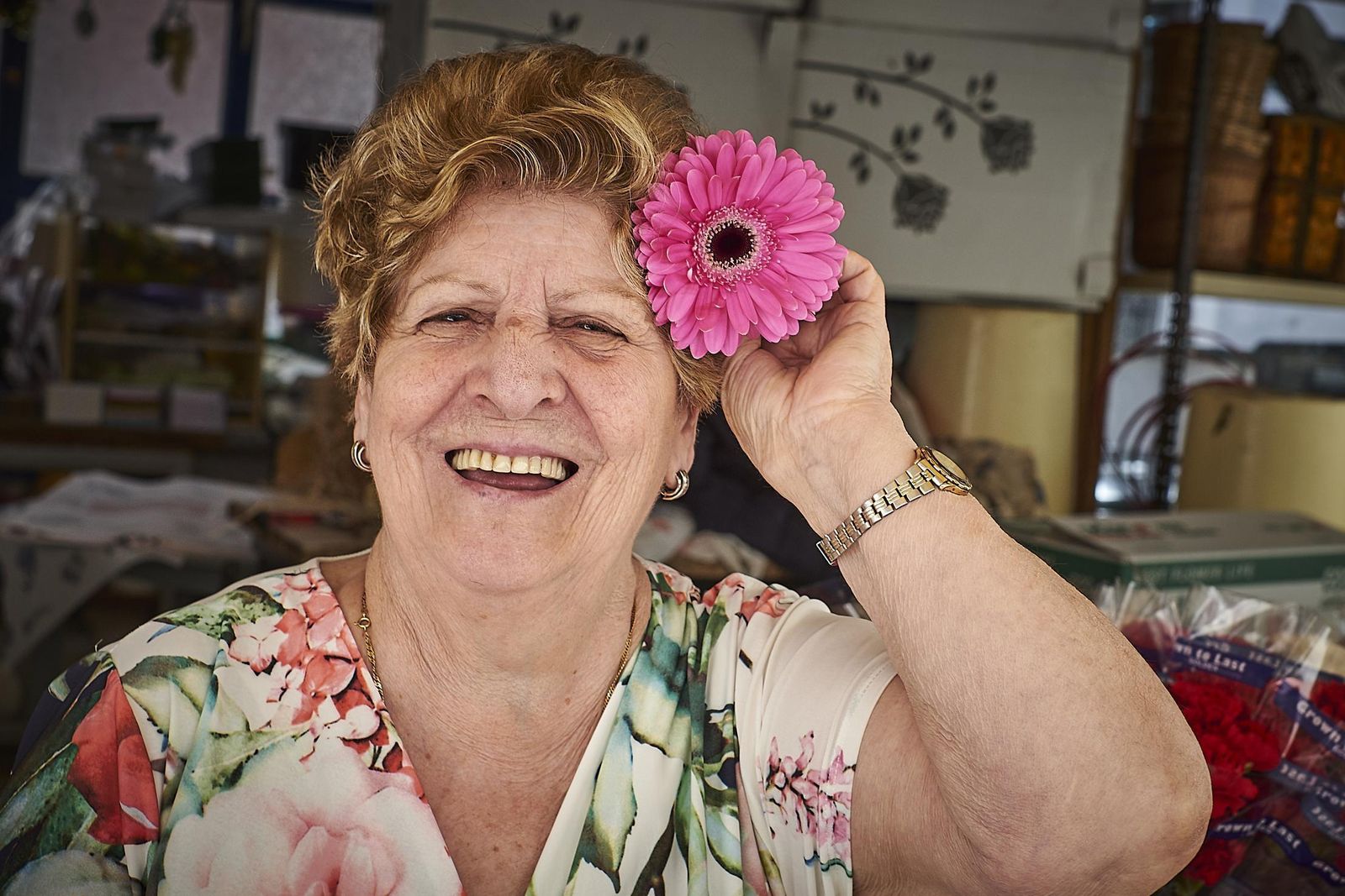 Mercedes Pecino bromea con una flor en su establecimiento.