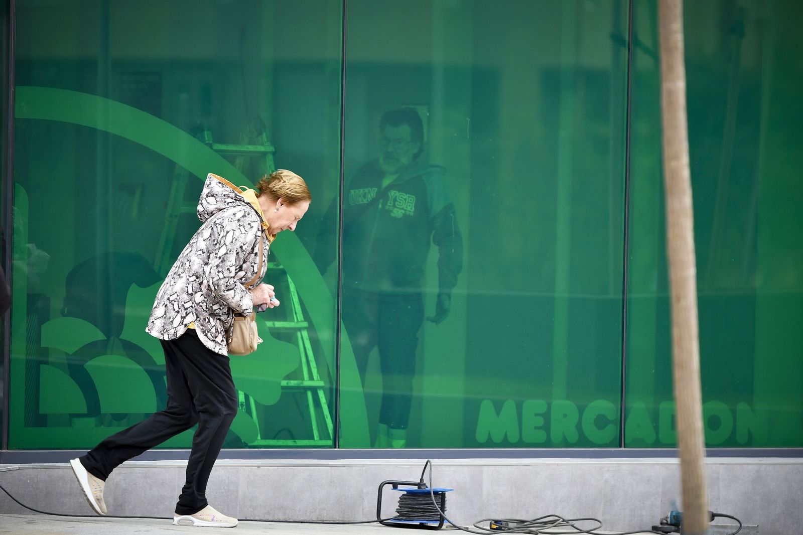 Una mujer intenta caminar en Almería pese al fuerte viento.