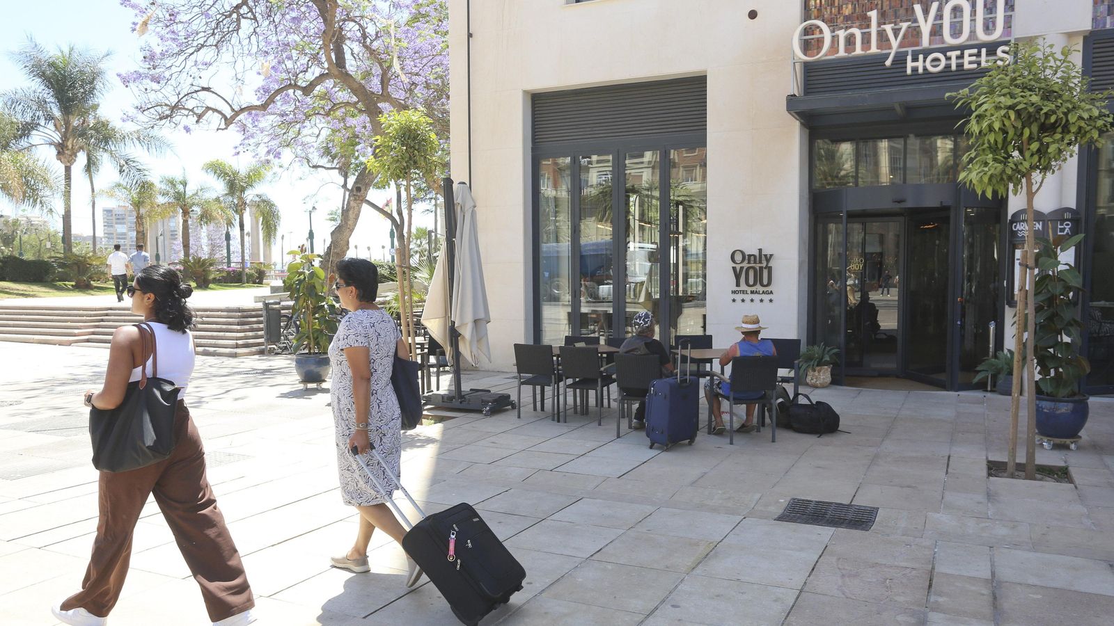 Varios turistas en la puerta de un hotel en Málaga capital.