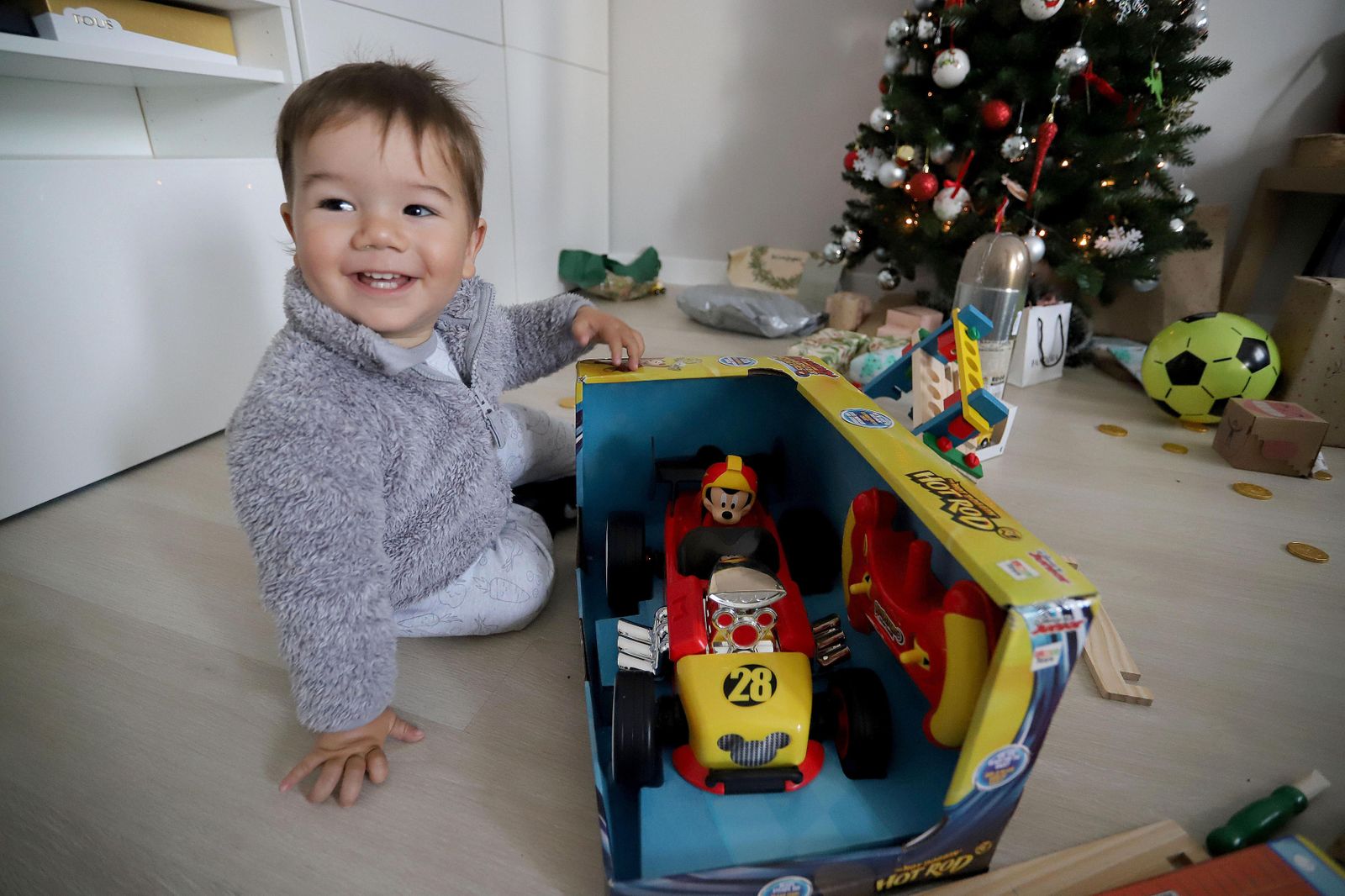 Un niño sonríe con un juguete en Navidad.