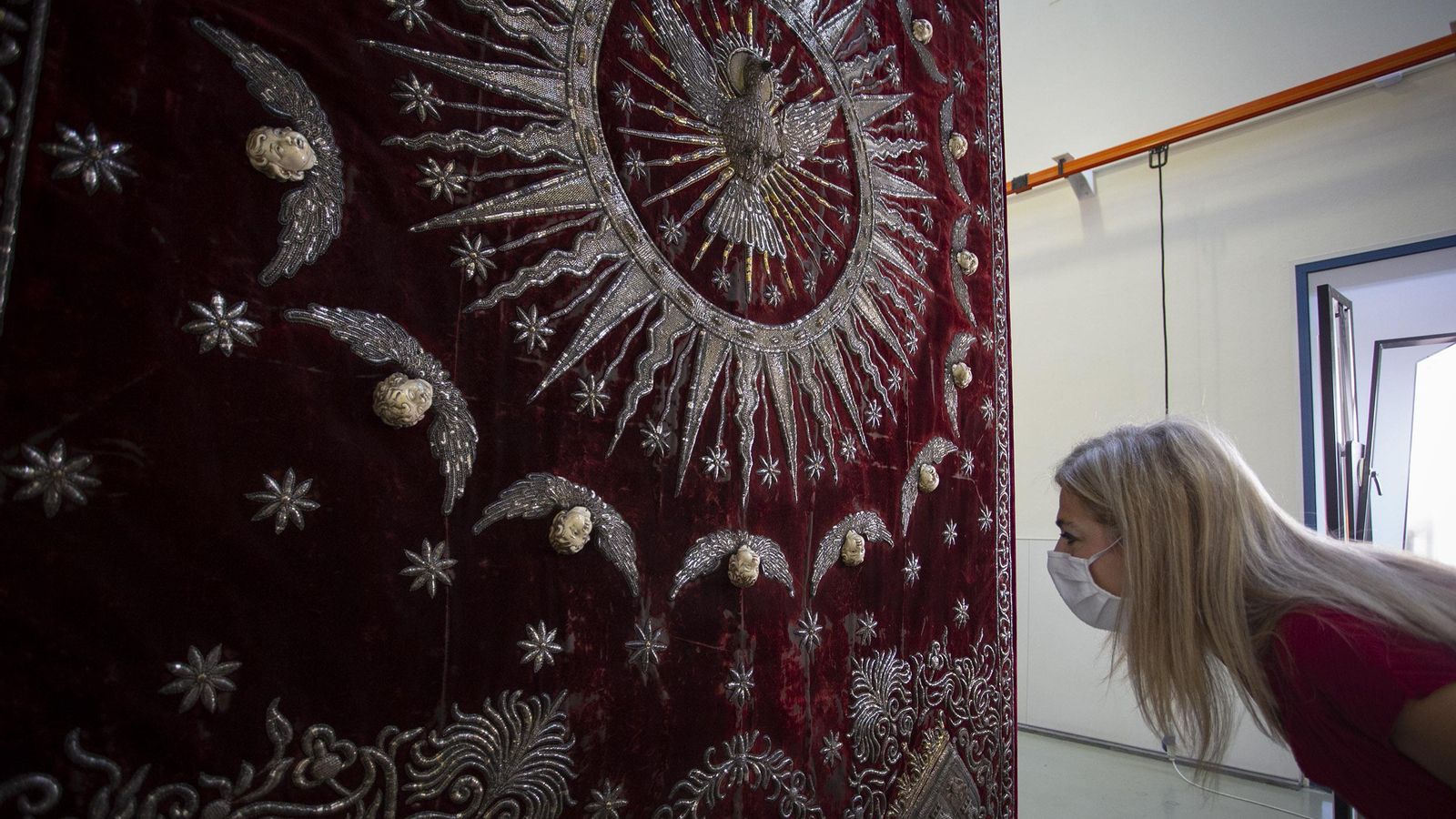 La consejera Patricia del Pozo observa el palio de la Virgen del Valle en el IAPH.
