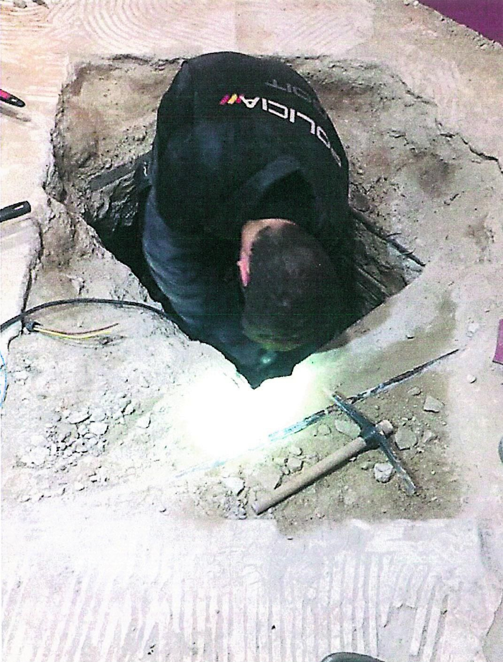 Un agente en la excavación realizada en la fosa séptica donde fueron hallados los cadáveres.