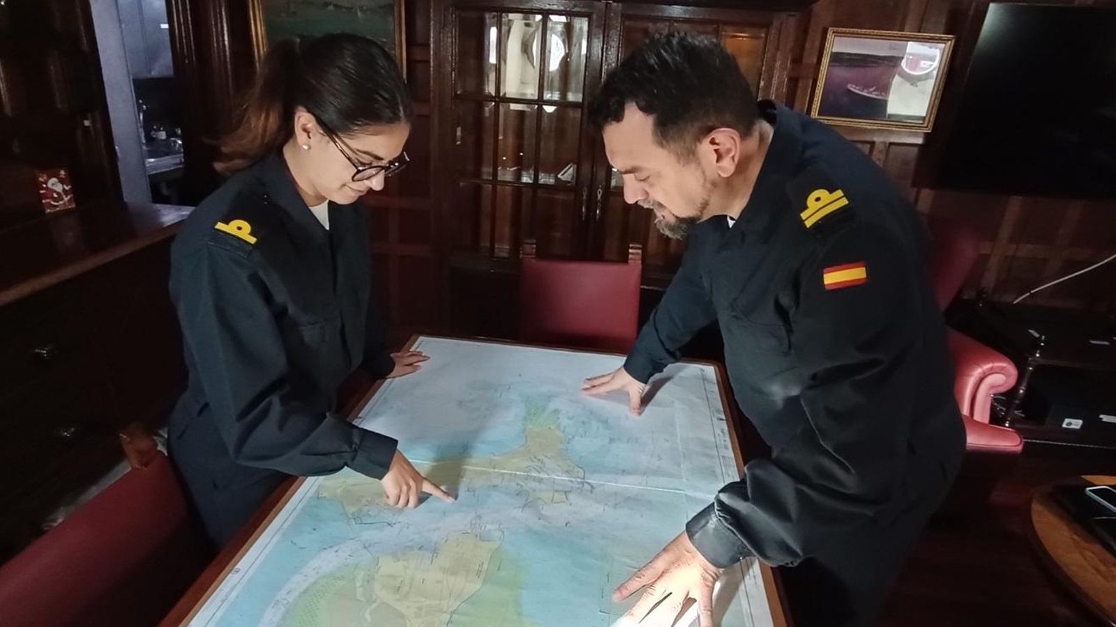 Oficiales del 'Juan Sebastián Elcano' comprueban las cartas de navegación antes del crucero.