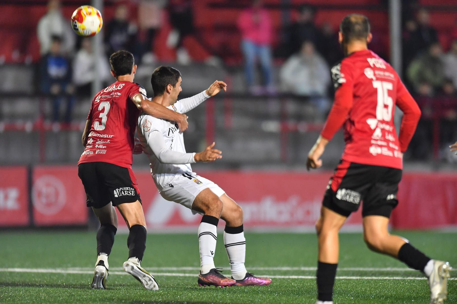 Juanjo Carmona, en presencia de Pozo, pugna con un jugador del Cartagena