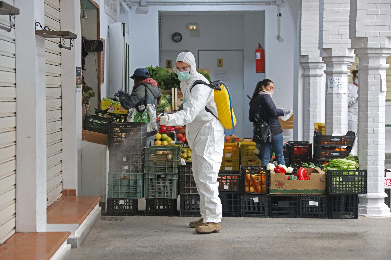 Tareas de limpieza cerca de un puesto de fruto y verdura.
