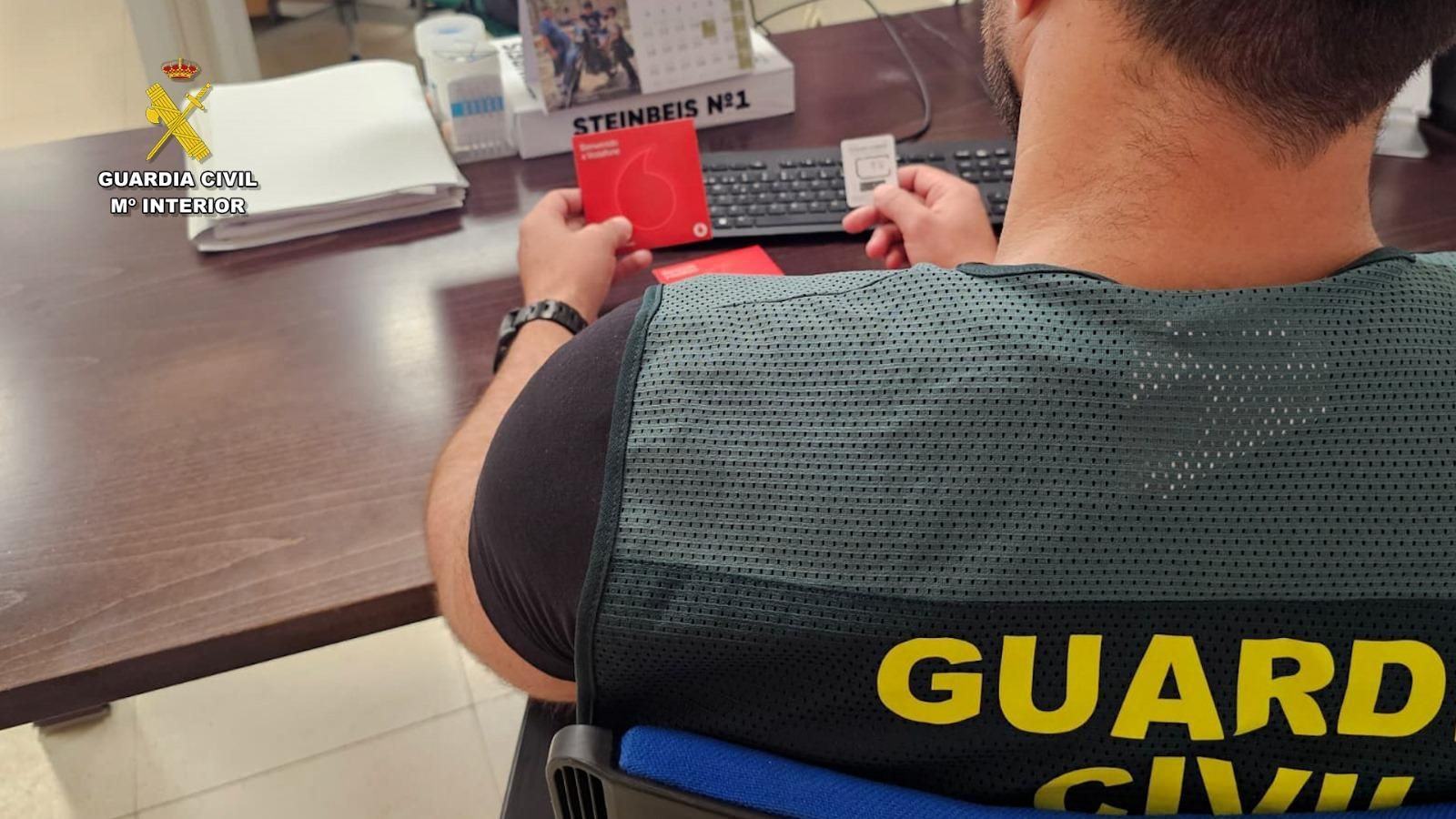 Guardia Civil con una de las tarjetas móviles con las que operaban.