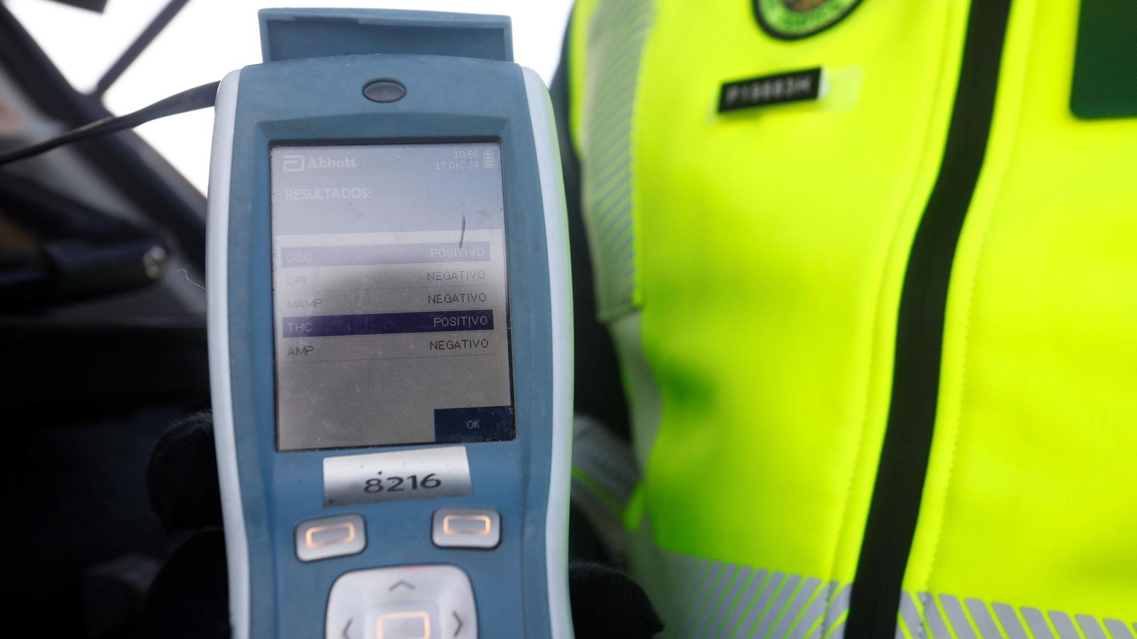 Un agente muestra el resultado negativo de una prueba de alcoholemia.