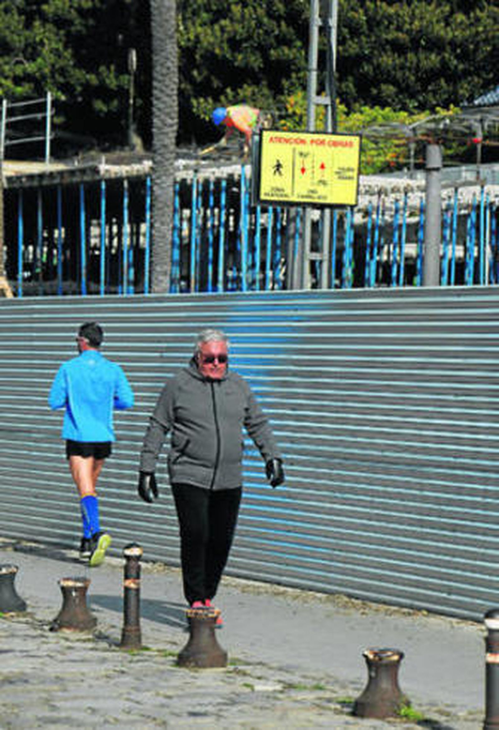 Dos peatones caminan junto a las obras del Paseo de Marqués de Contadero que adjudicó Urbanismo.