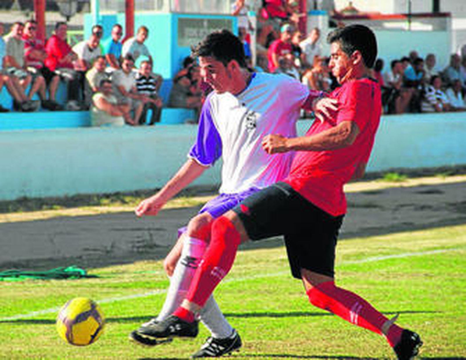 El barbateño Bollo adelanta la pierna izquierda para frenar el avance de Mora, jugador del Olont.