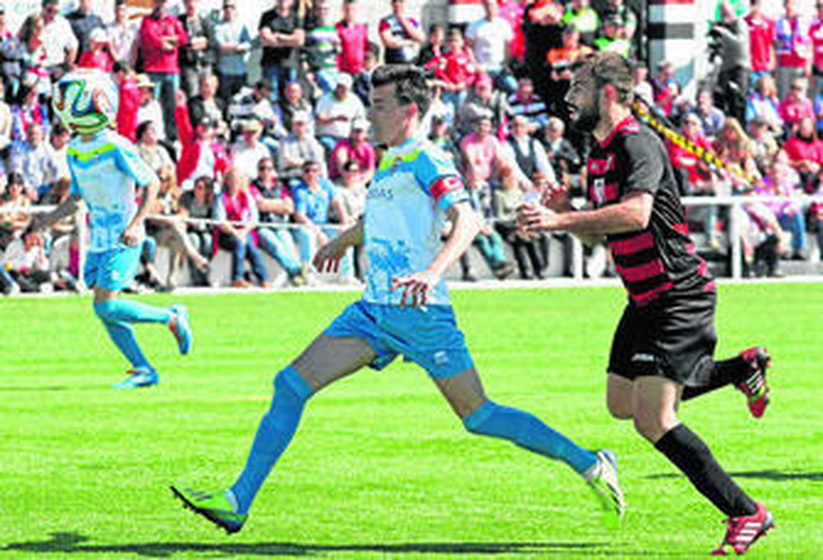 Javi Chico controla el balón seguido por un jugador del Gerena.