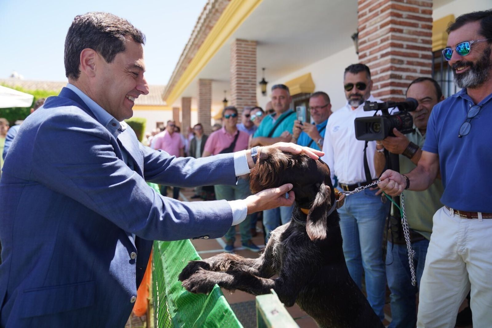 Moreno acaricia a un perro tras su encuentro con dirigentes de la Federación Andaluza de Caza.
