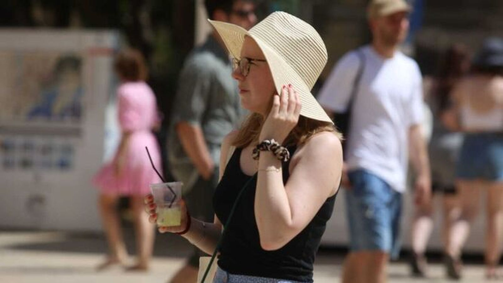 Una mujer se protege del sol con un sombrero.