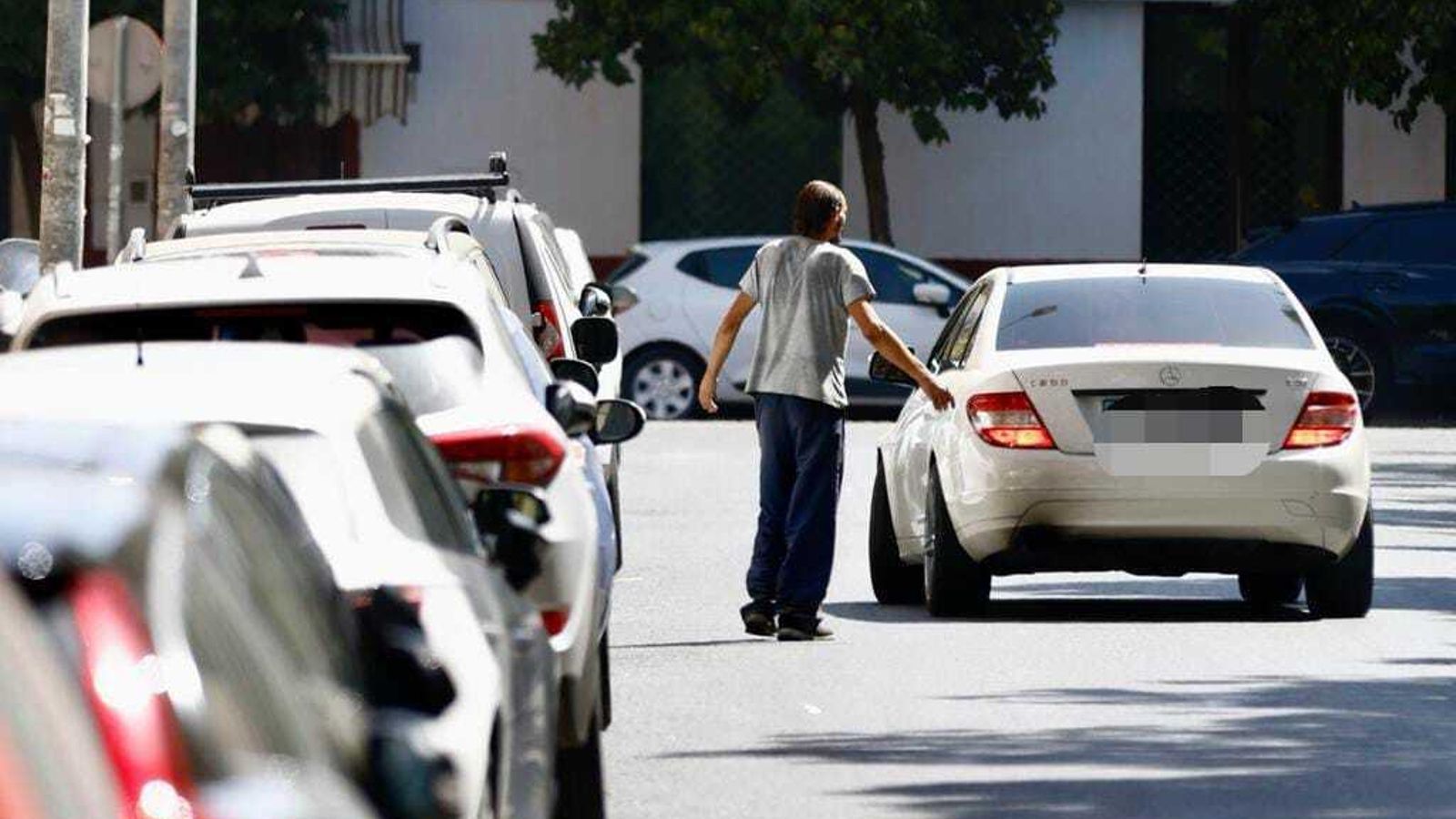 Un aparcacoches se dirige a un vehículo en la calle Luis Arenas Ladislao, donde habrá zona azul.