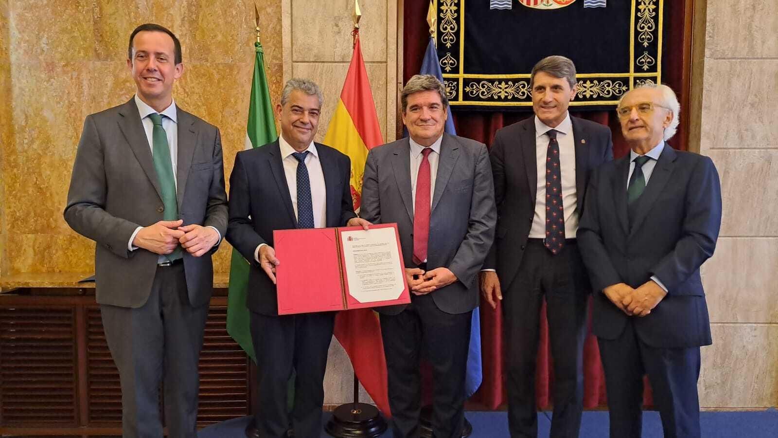 Momento en el que el ministro de Integración, Seguridad Social y Migraciones entrega el documento que hace a la Universidad de Almería propietaria del inmueble del Paseo de Almería que ahora ya es sede de la institución académica