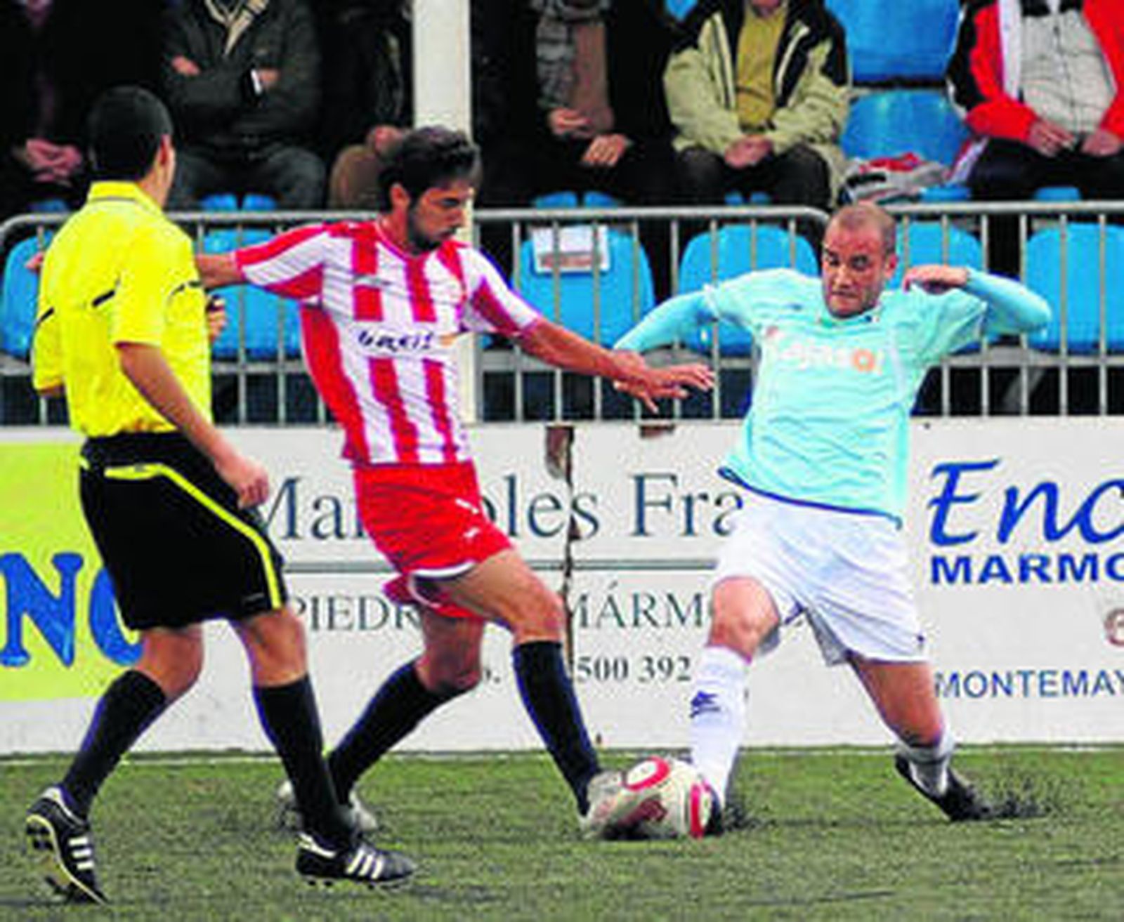 Pineda trata de robar un balón al jugador del Almería B García Márquez ante la mirada del árbitro.