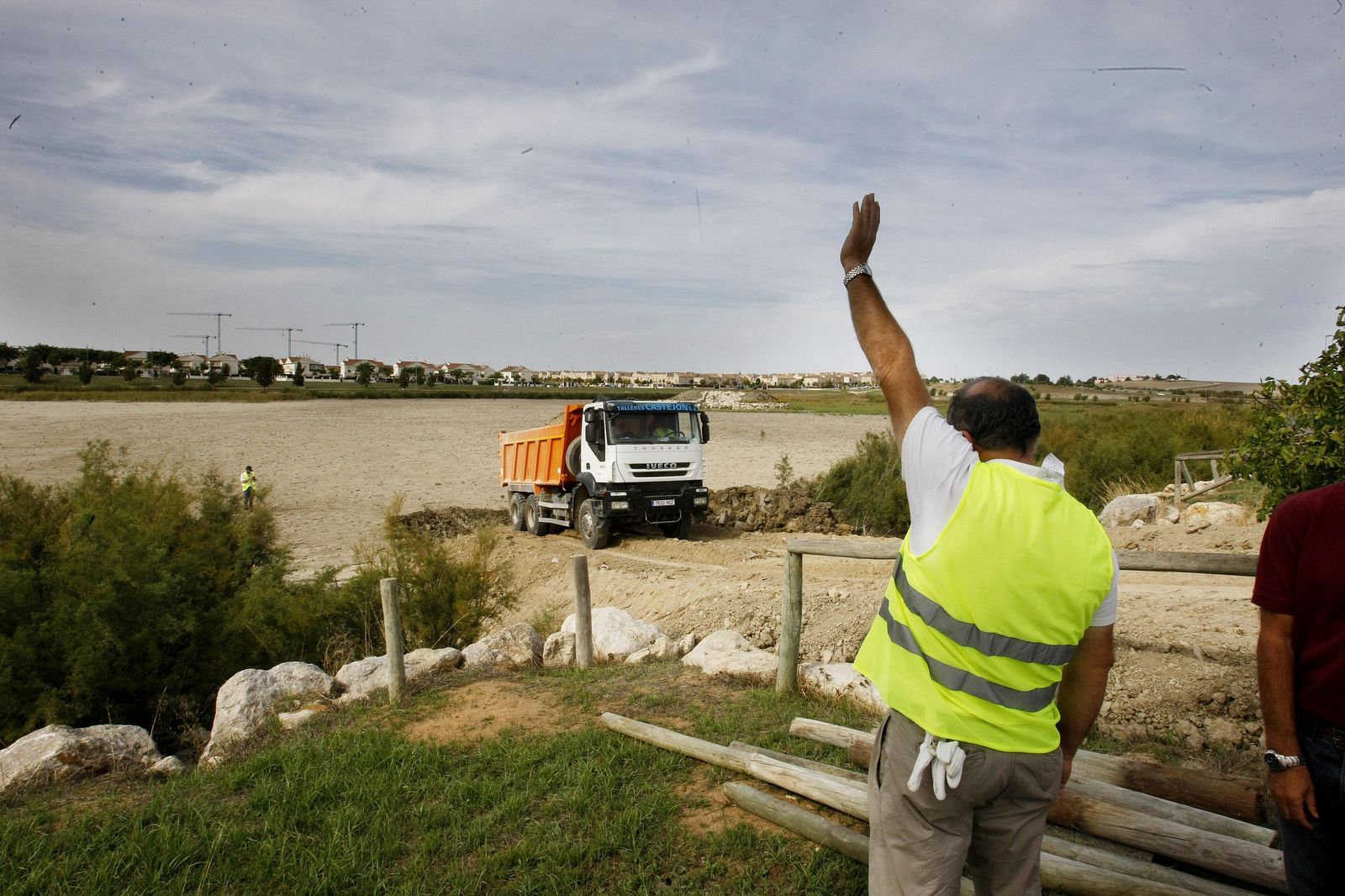 Un operario llama a un camión cargado de materiales durante unas obras en la zona de Torrox.