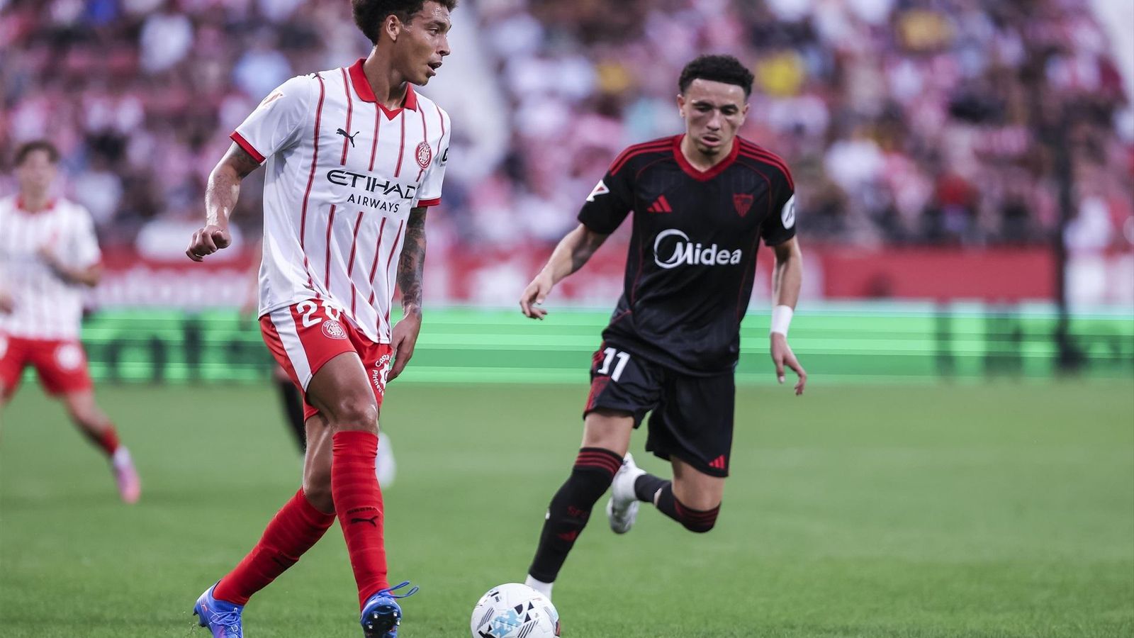 Vargas presiona a Witsel durante el partido en Montilivi.