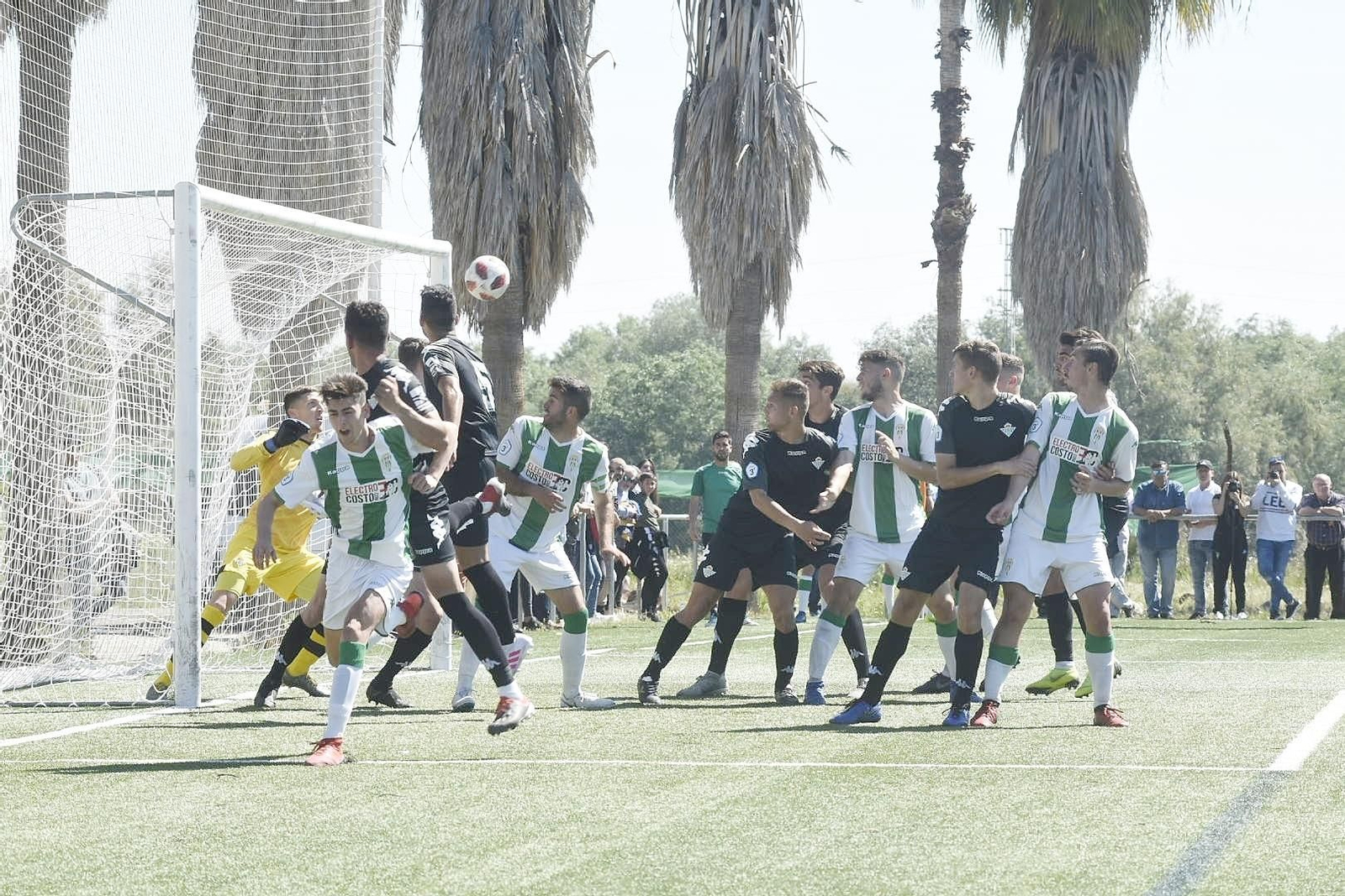 Jugadores del Córdoba B y el Betis Deportivo a la salida de un saque de esquina.