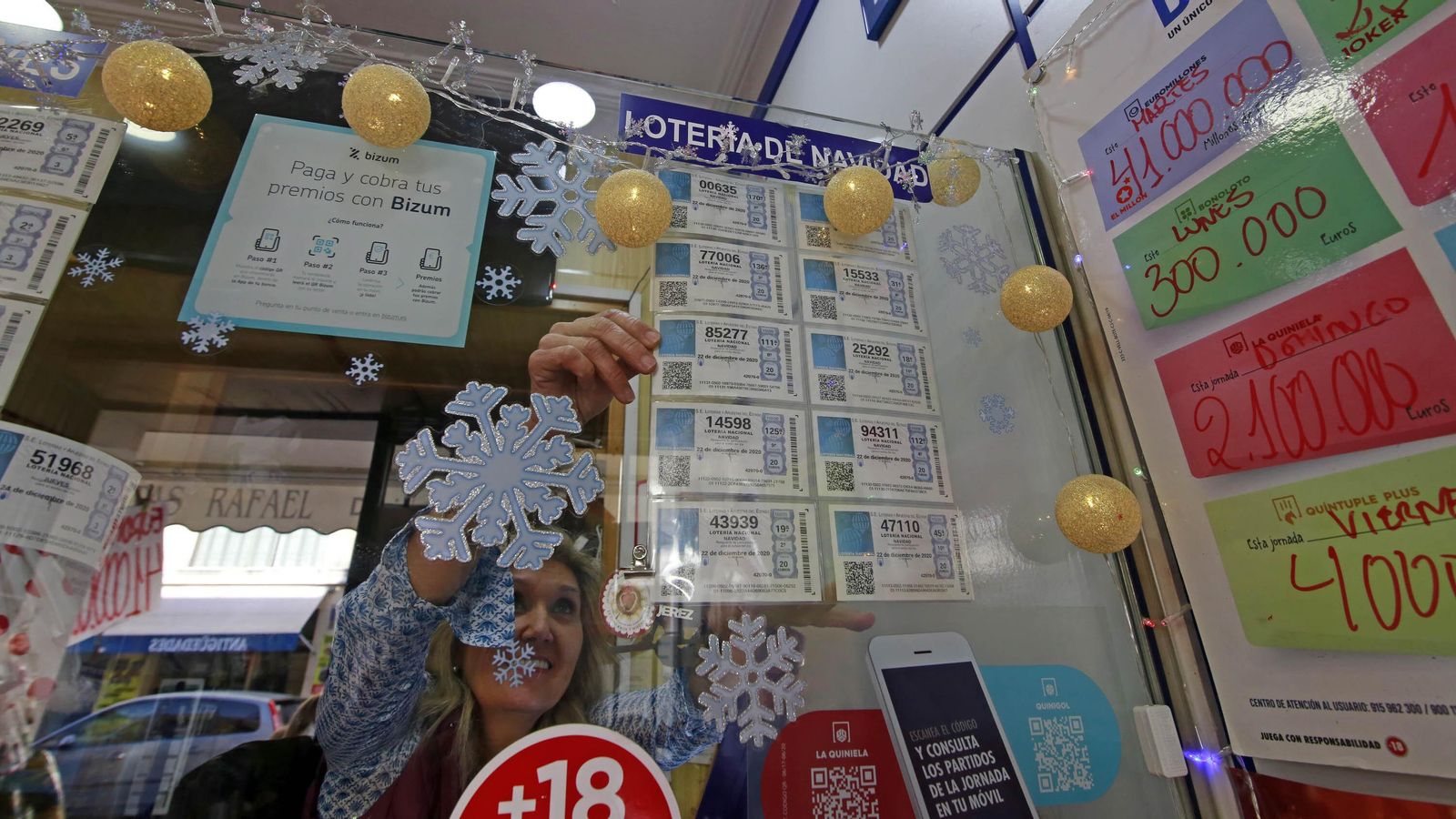 La administradora del despacho de loterías de la calle Arcos, sacando décimos de un billete.