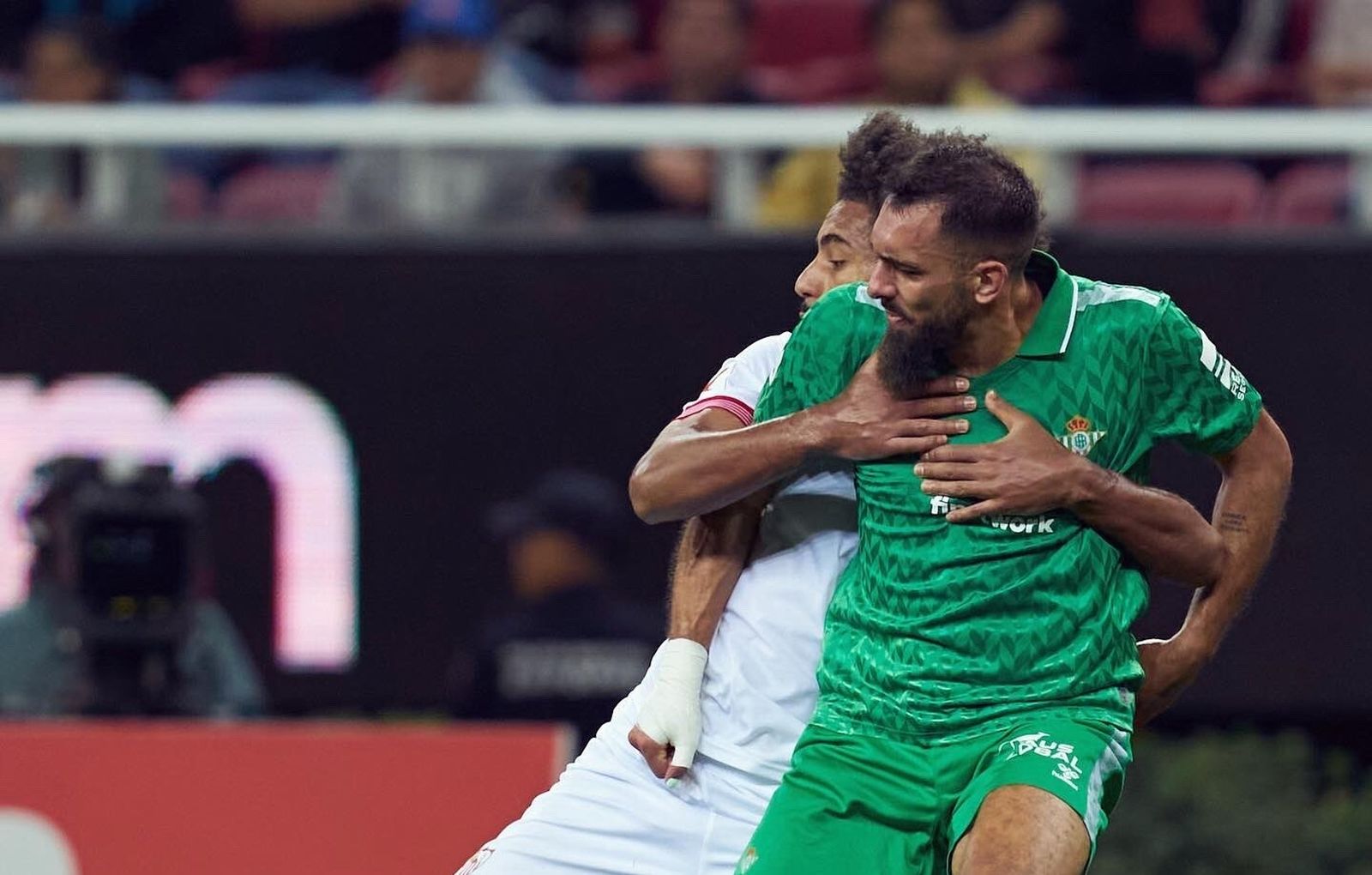 Borja Iglesias pelea con Badé en una jugada del derbi.