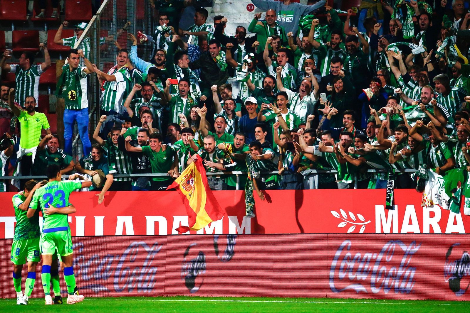Los jugadores del Betis celebran con la afición verdiblanca un gol en la campaña 2018-19 en Girona.