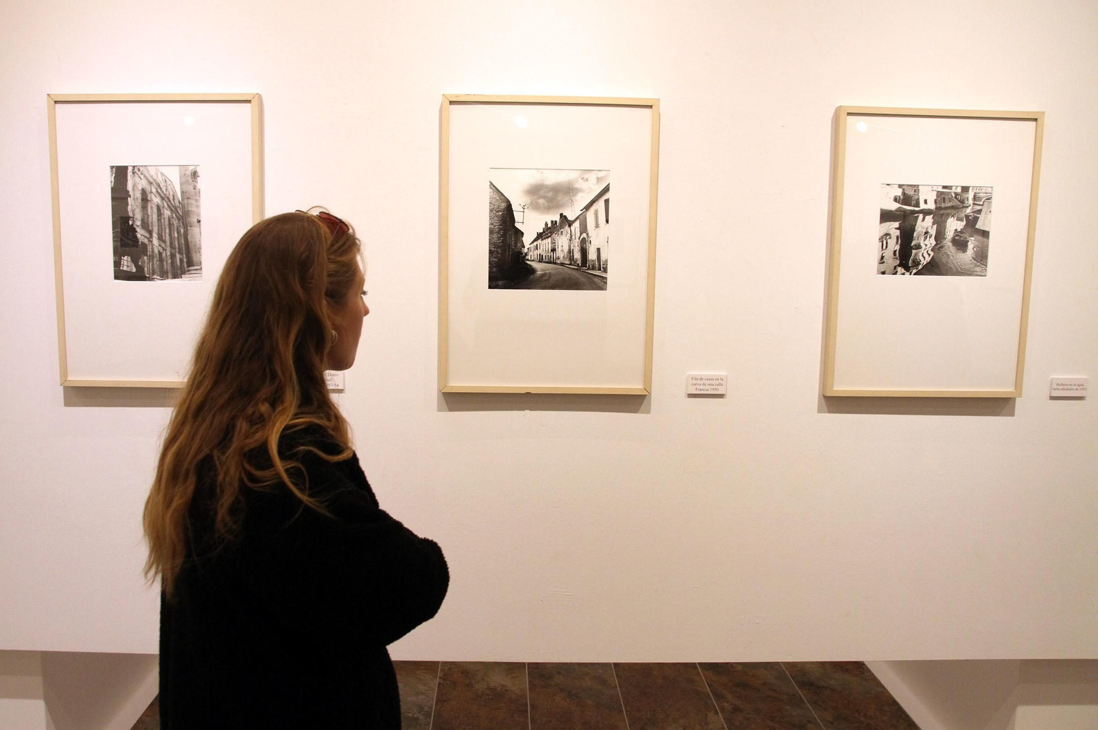 Una mujer observa las fotografías de Bernhard Wicki durante la inauguración en la Sala de la Provincia.