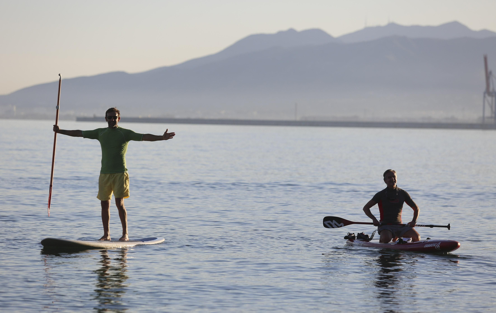 Dos personas sobre sus tablas en El Palo.