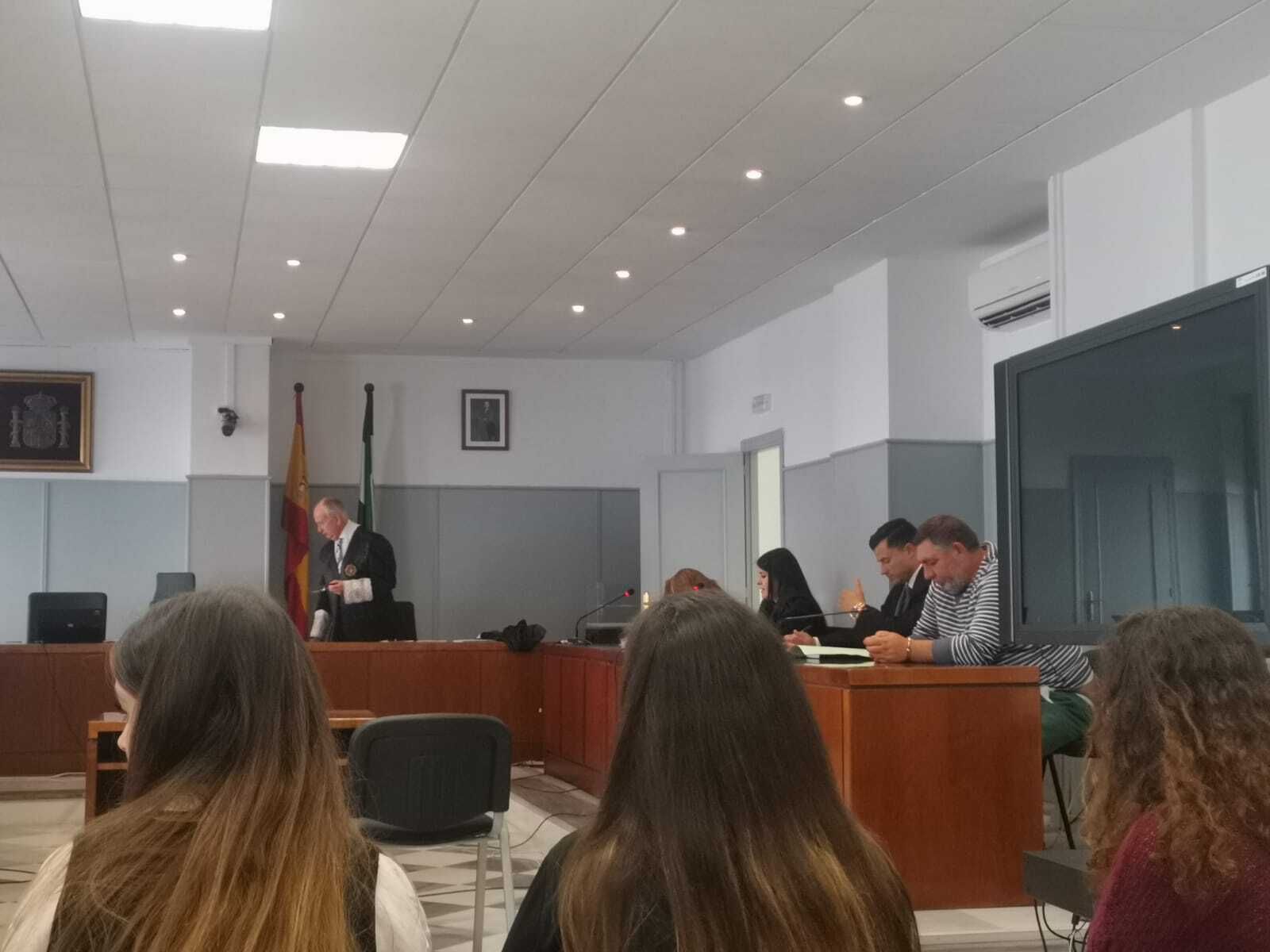 Junto a la pantalla, el acusado por el homicidio aguarda a conocer el veredicto.