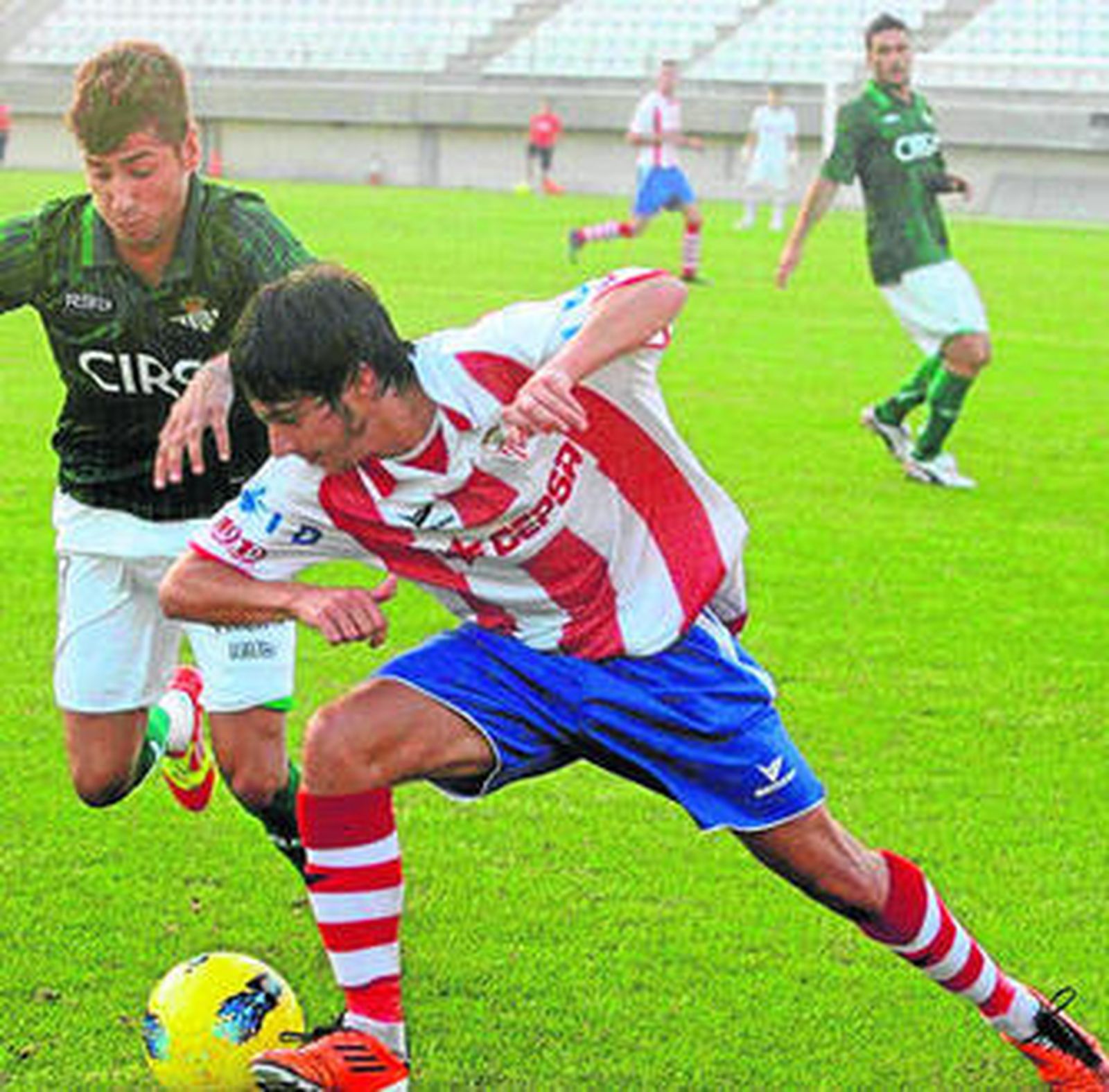 El debutante Antoñito controla el balón ante la oposición de un adversario.