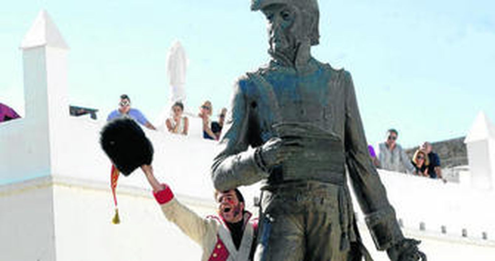 El público mira la escena desde los balcones junto a la Puerta del Retiro, mientras uno de los actores proclama la victoria.