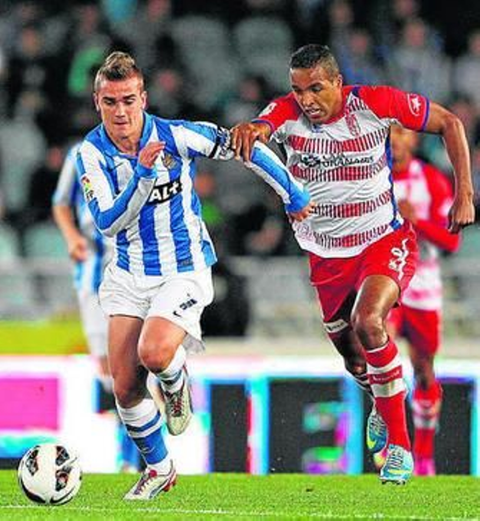 Griezmann conduce el balón perseguido por El Arabi.