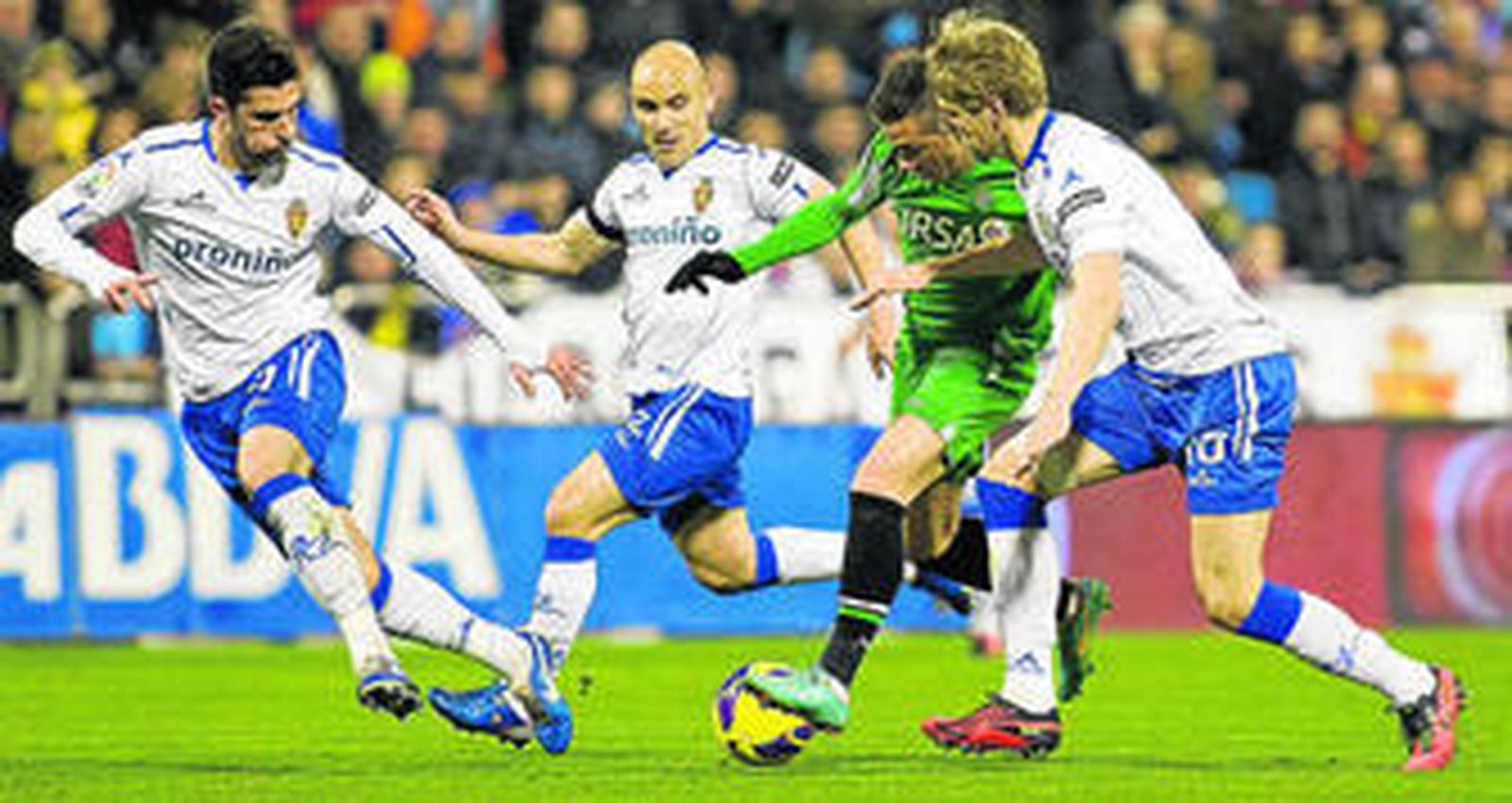 Rubén Castro controla el balón rodeado por tres adversarios del Zaragoza, Álvaro González, Movilla y Loovens.