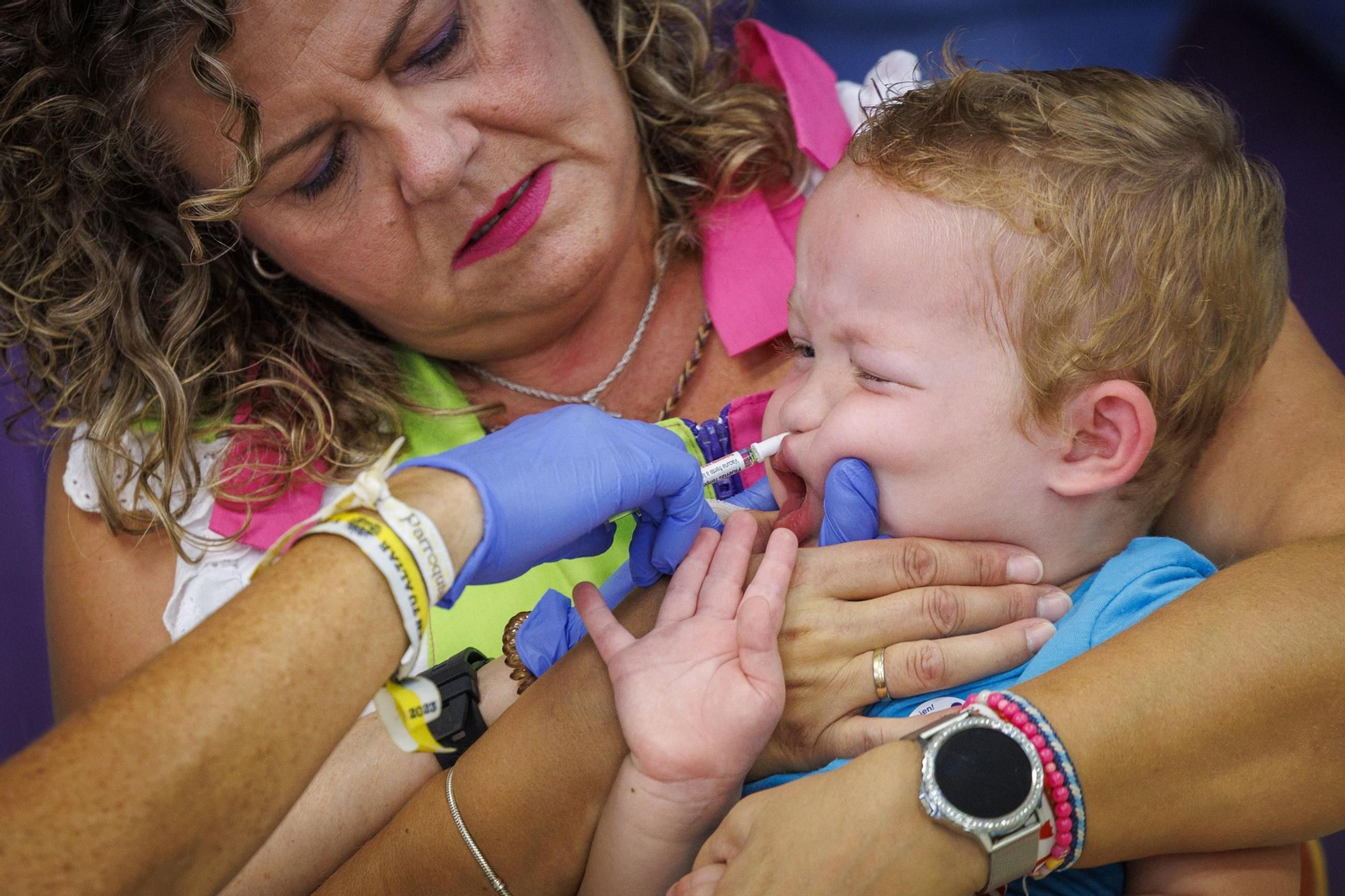 Una sanitaria vacunando a un niño.