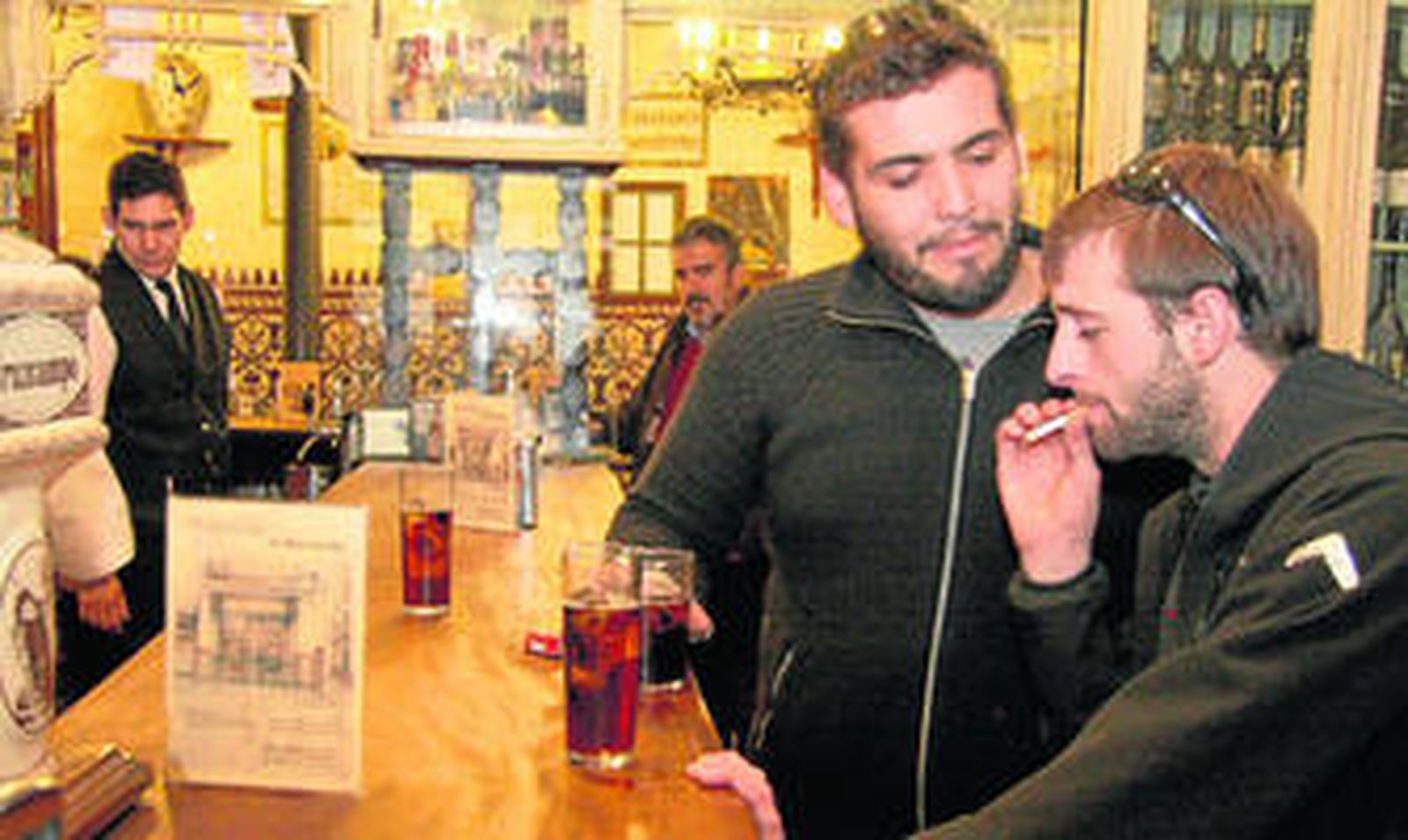 Jóvenes fumando en un bar, una imagen que no se repetirá a partir del próximo mes de enero.