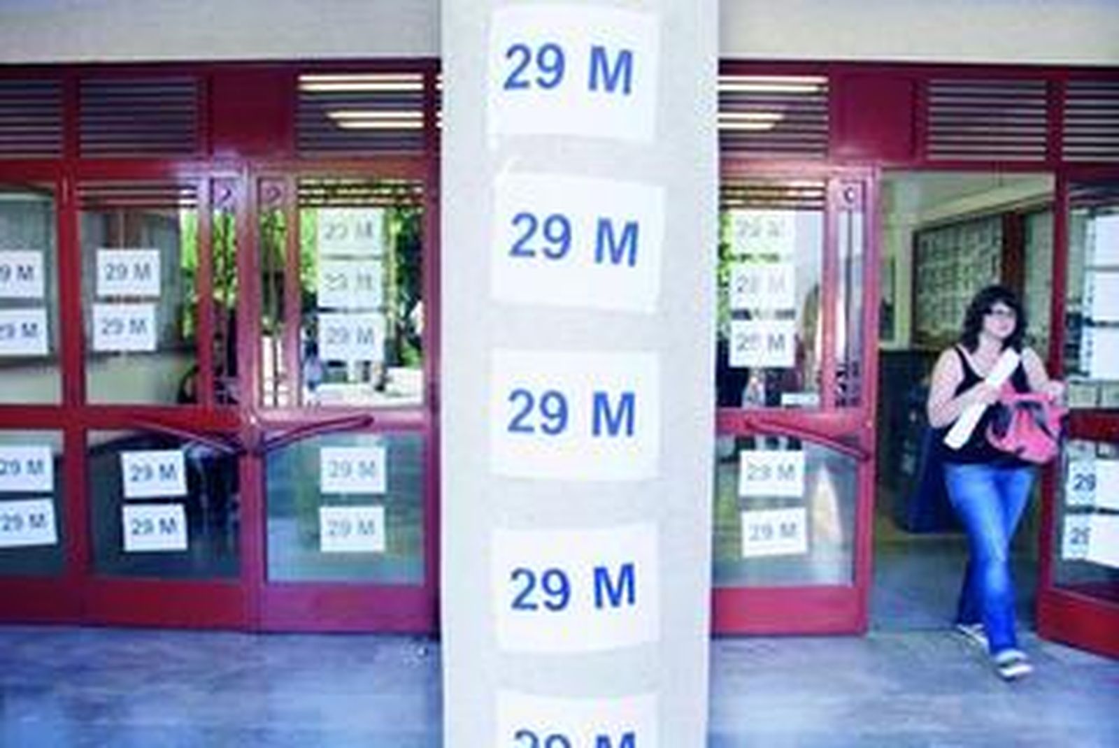 Fachada de la Escuela de Arquitectura de Granada con carteles en apoyo a la manifestación del viernes (29-M) en Madrid.