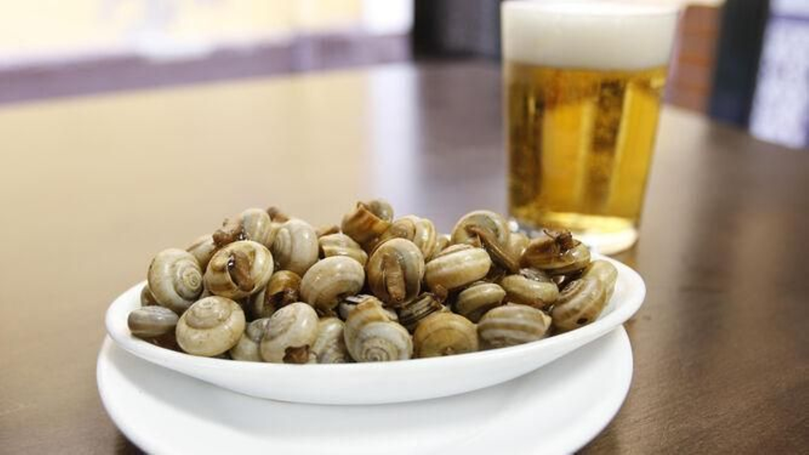 Una cerveza fresquita junto a una tapa de caracoles, combinación ganadora en estas fechas.
