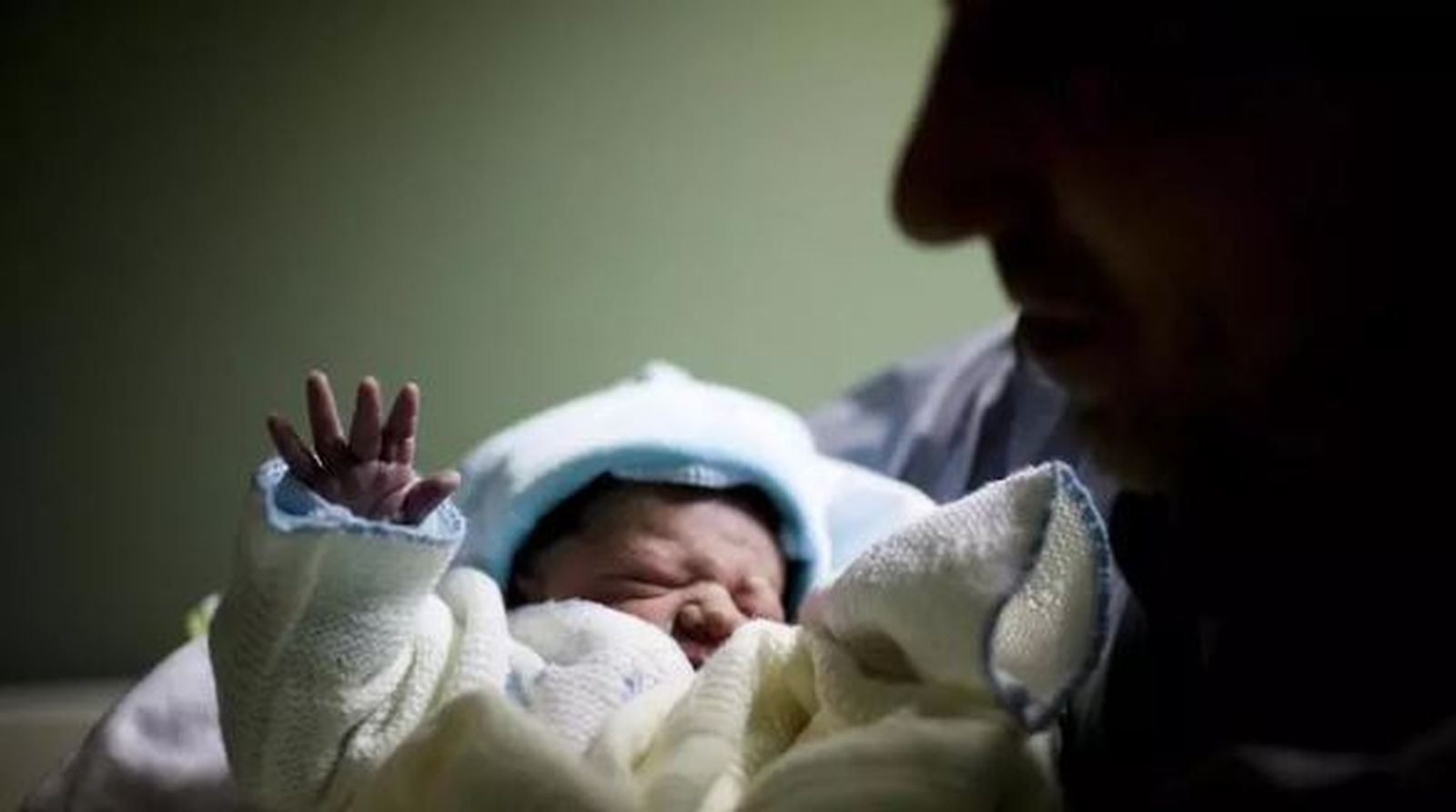 Una madre sostiene a su hijo en brazos.