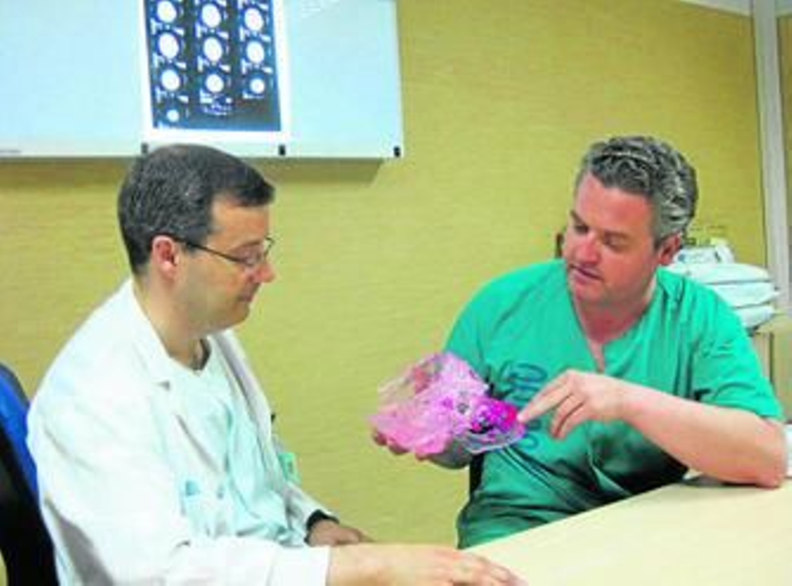 El neurocirujano Bienvenido Ros (izq.) y el cirujano maxilofacial Manuel Martínez analizan el molde de un cráneo.