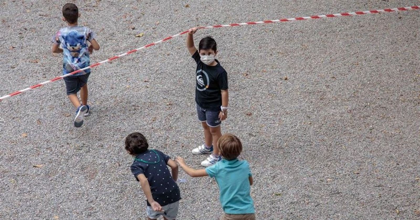 Niños con mascarilla en el recreo.