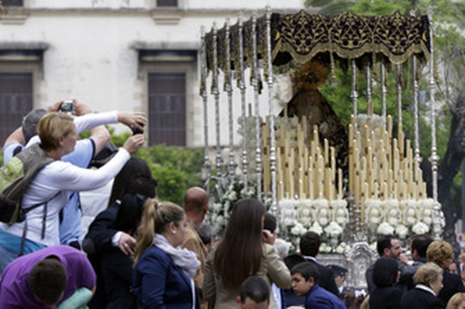 Un grupo de turistas fotografiando, el pasado Viernes Santo, a la Virgen de la Concepción a su paso por la Alameda Cristina. /Miguel Ángel González