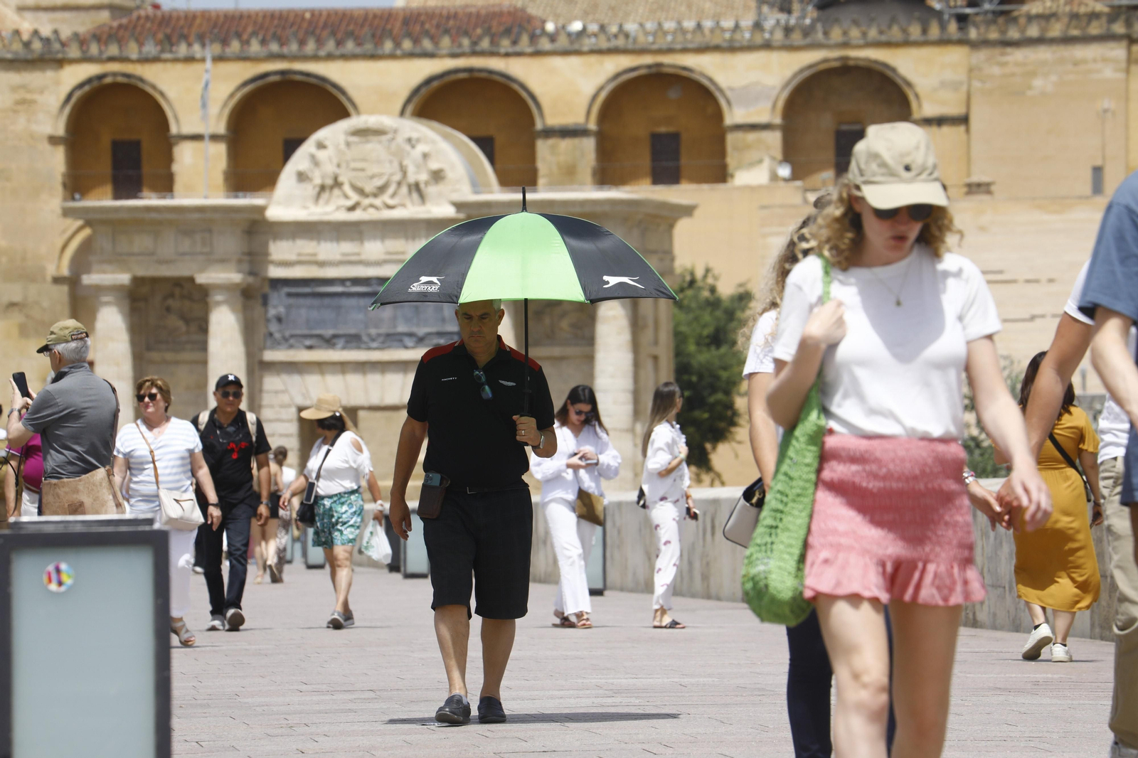 Un grupo de turistas pasean bajo el sol en Córdoba.