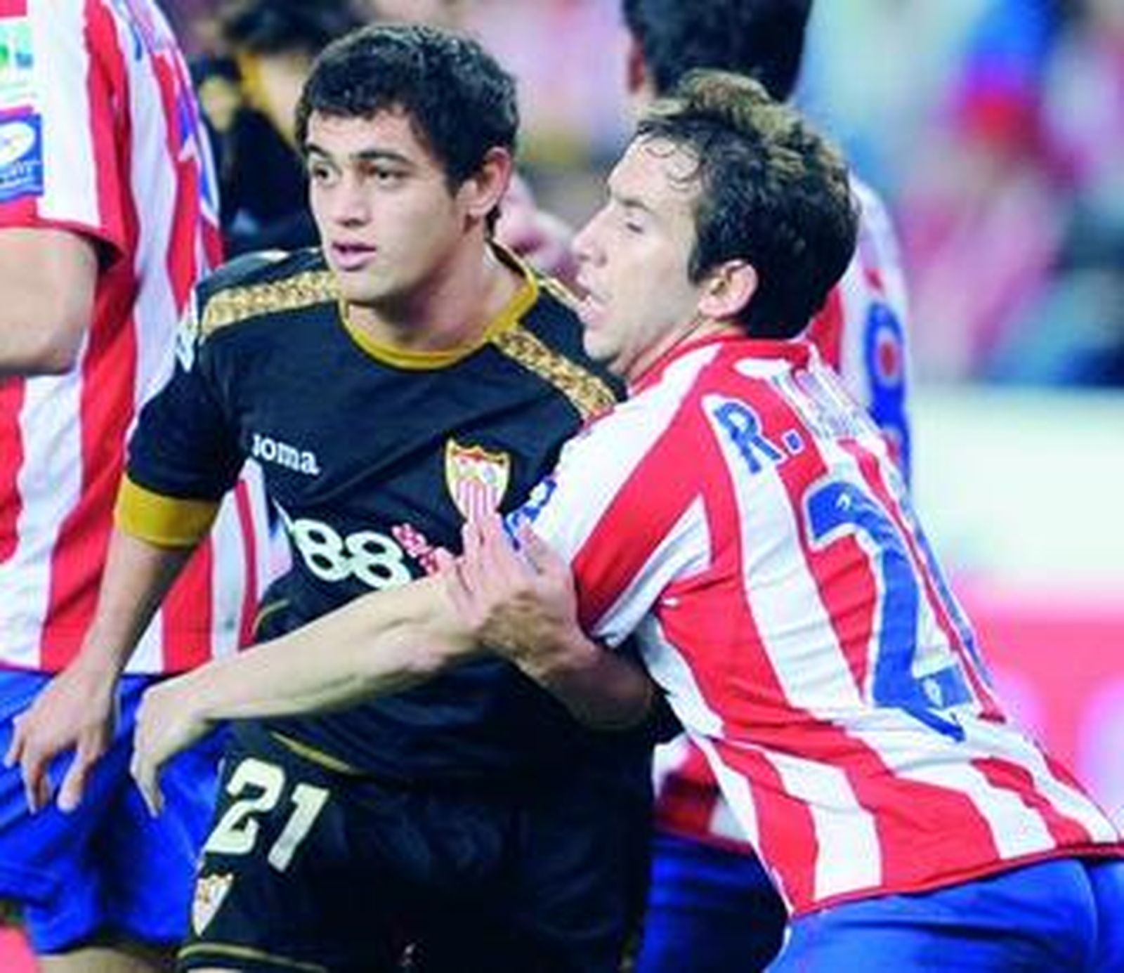 Raúl Cámara agarra a Acosta en una constante de todo el partido con diferentes sevillistas.