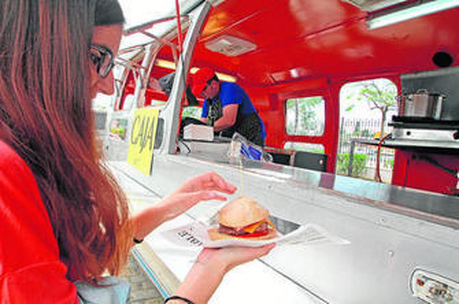 Una joven compra una de las hamburguesas elaboradas en una 'foodtruck', en la edición pasada.